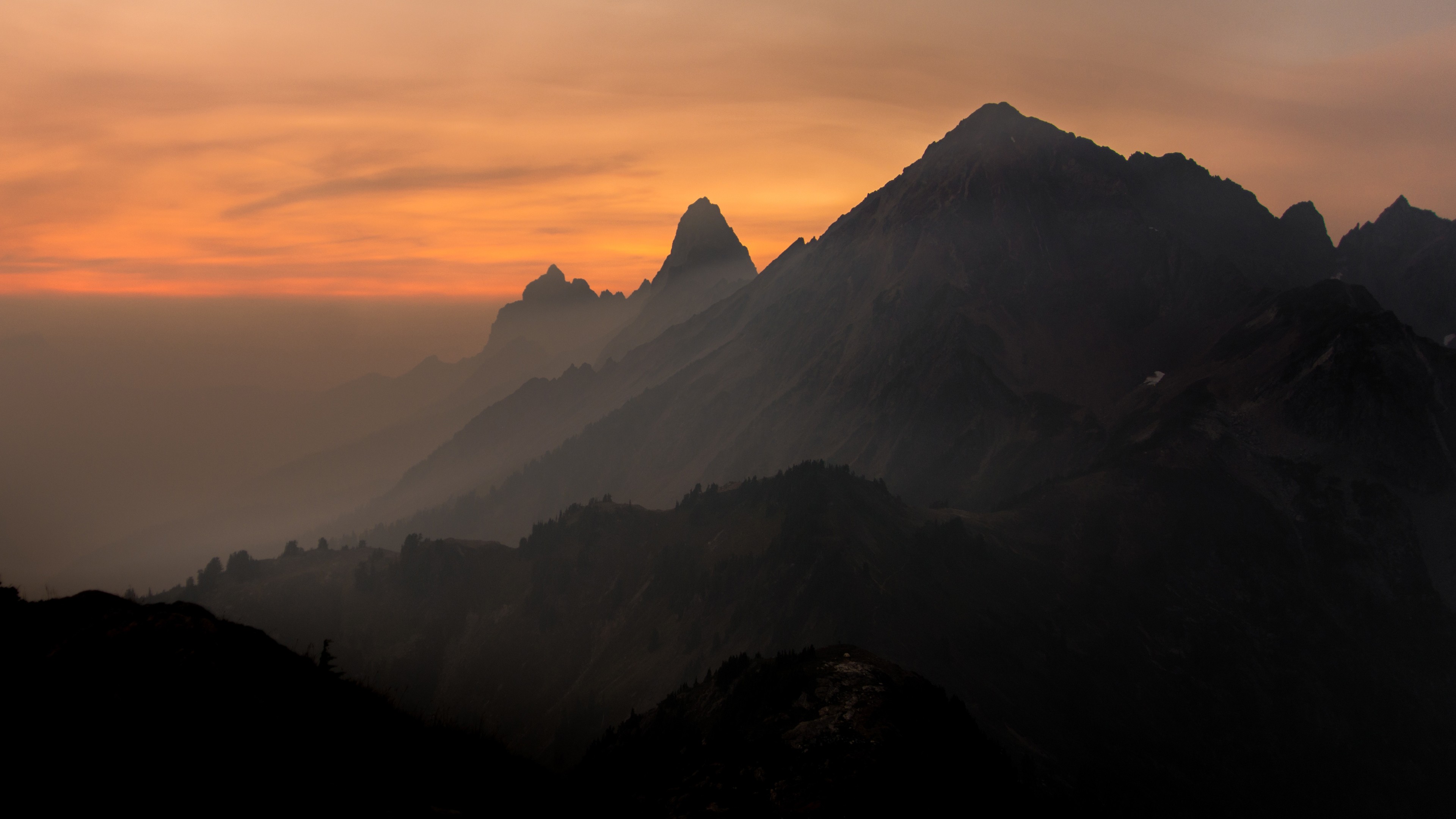 Mountains shrouded in mist during sunset HD Wallpaper