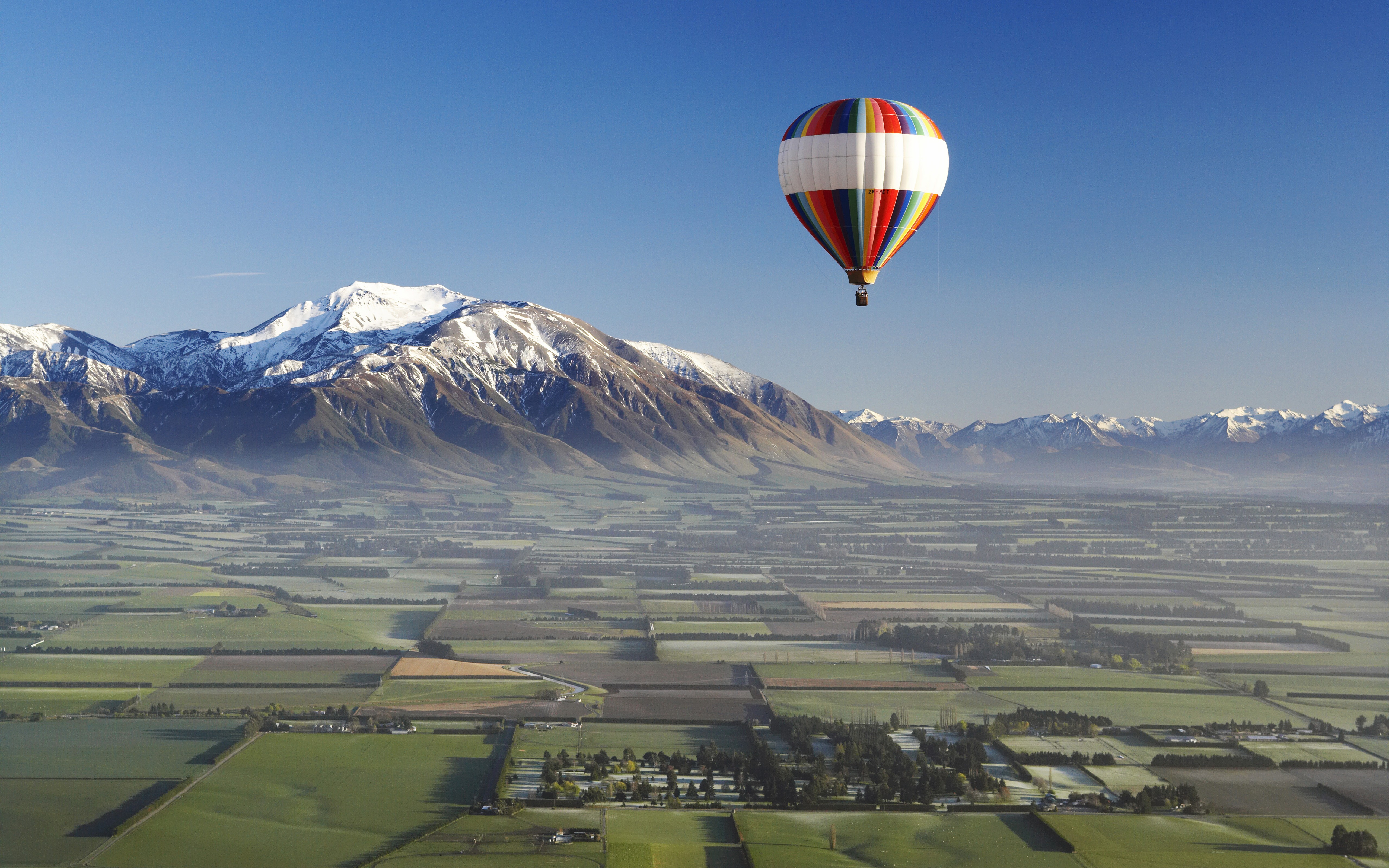 Hot air balloon over snowy mountains in New Zealand HD Wallpaper
