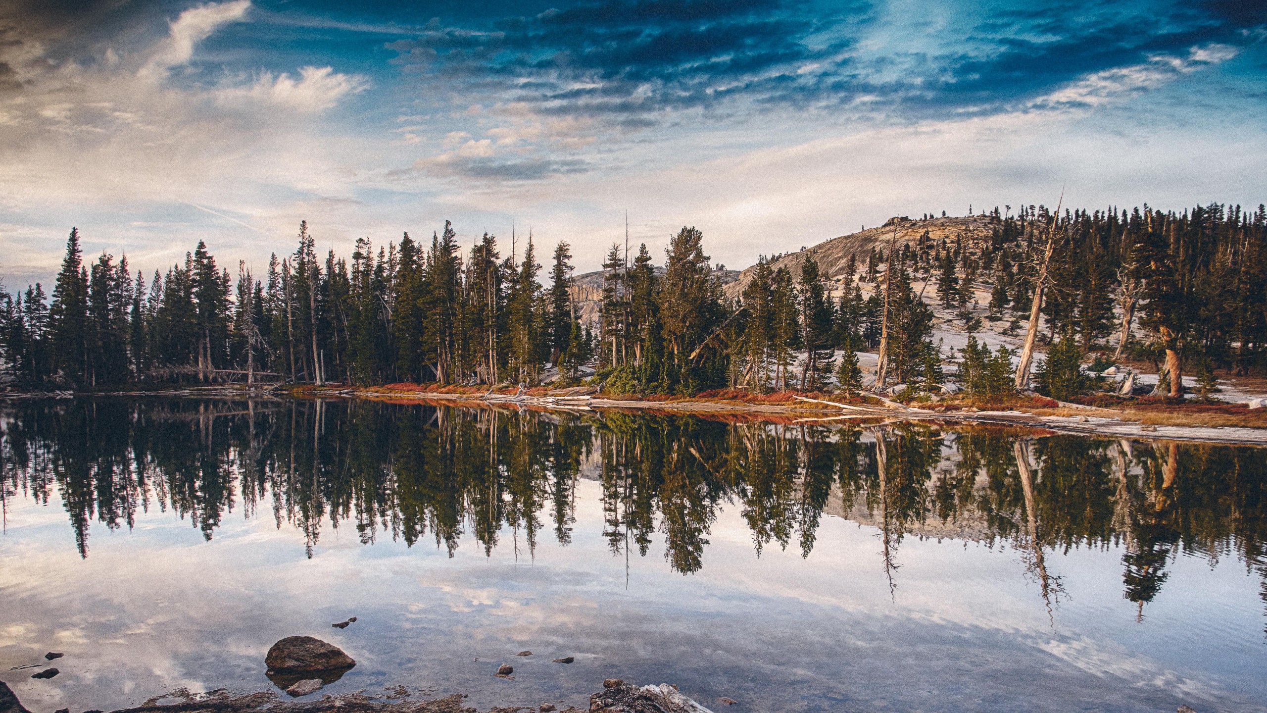 Lake reflection of trees and mountains under cloudy sky HD Wallpaper