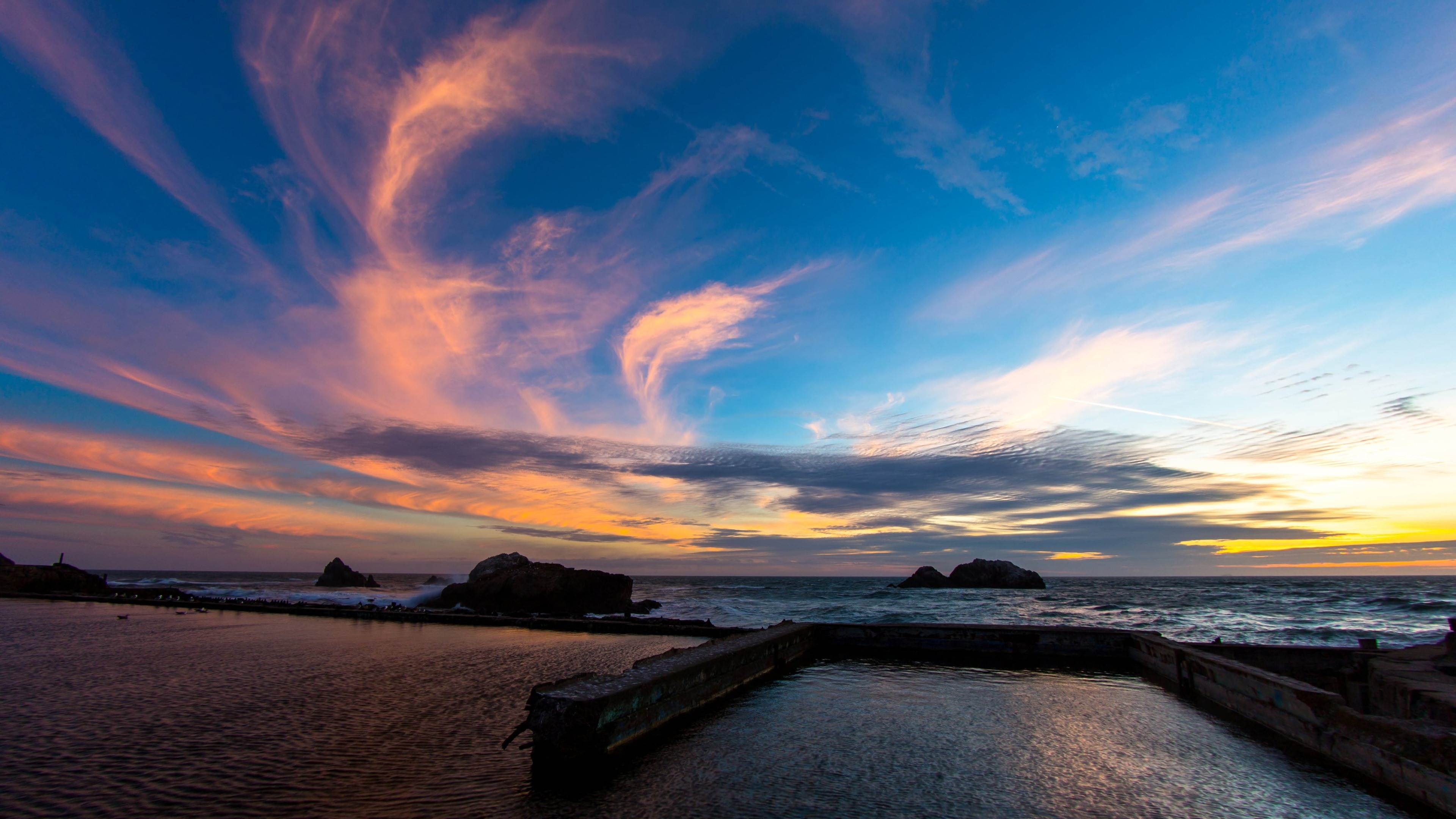 Sunset over the ocean with clouds and a pool HD Wallpaper