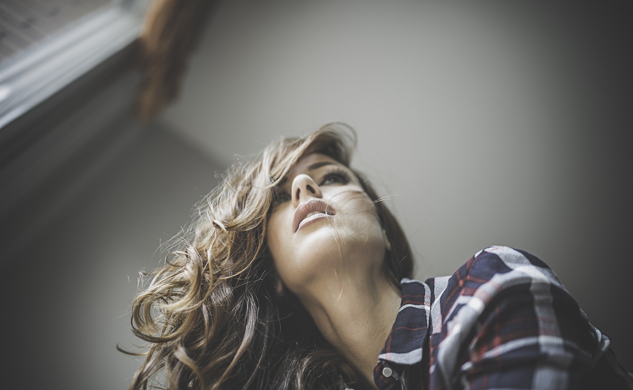 Woman with curly brown hair looking up HD Wallpaper