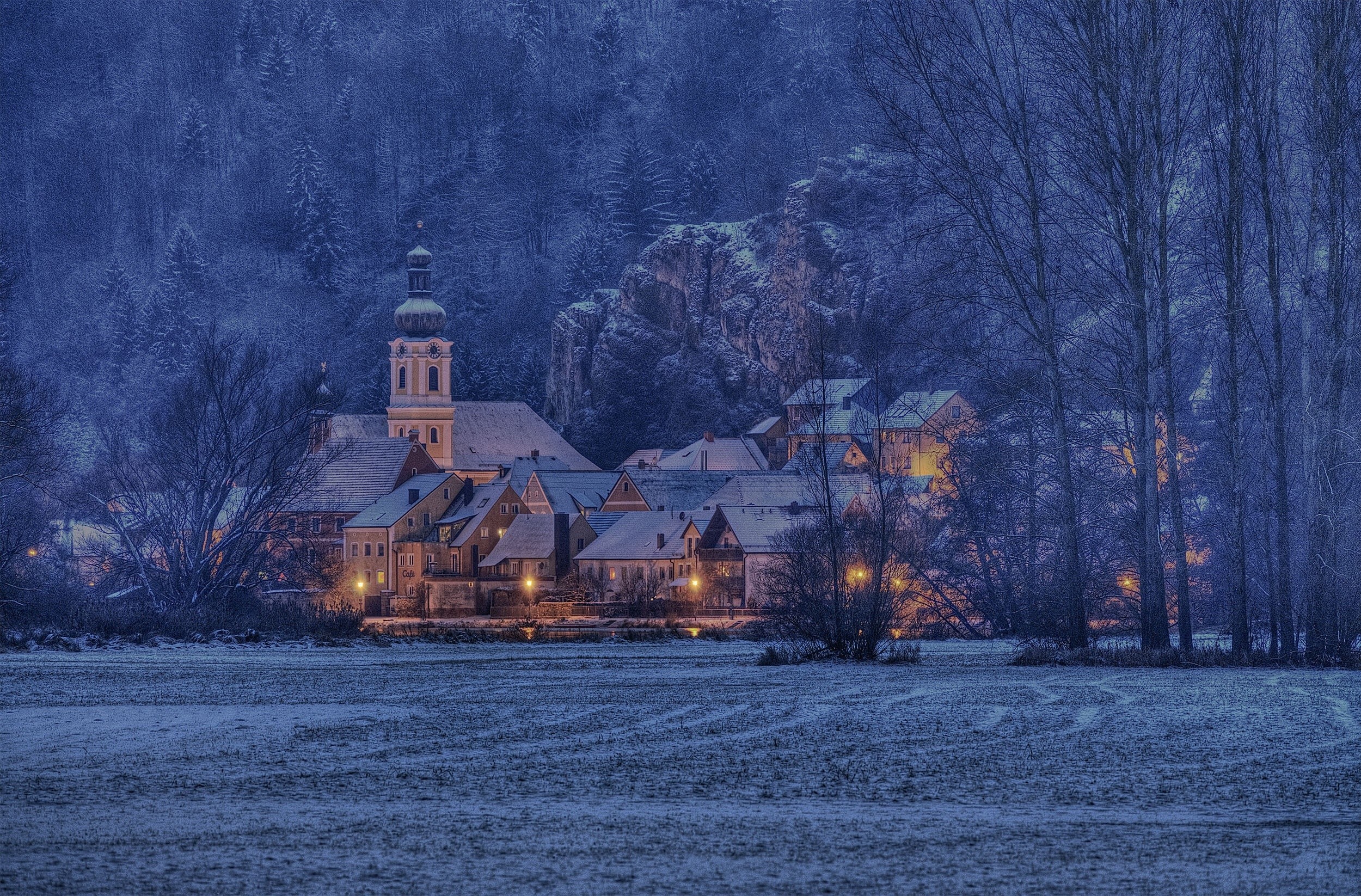 Winter landscape with a snow-covered church and village HD Wallpaper