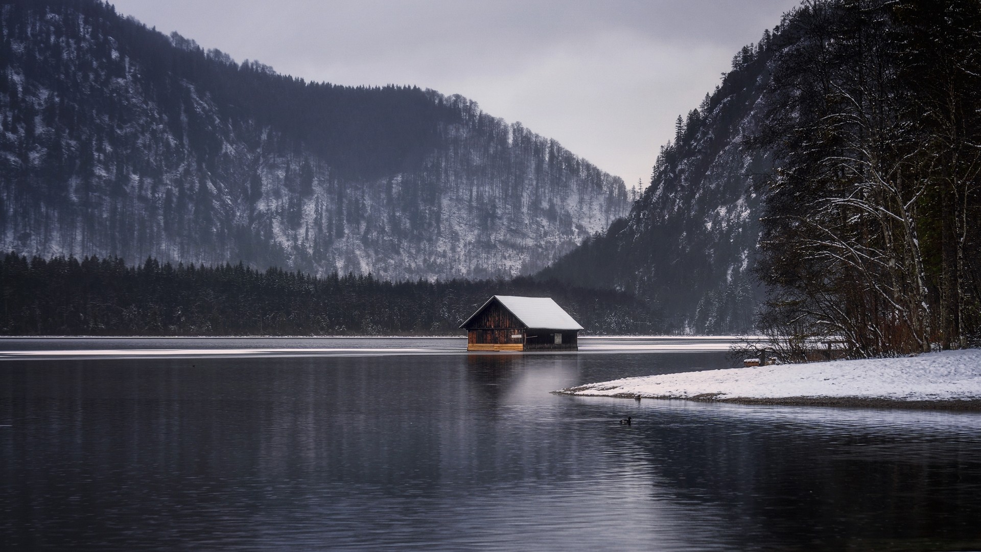 Wooden boathouse on a lake with snow-covered mountains HD Wallpaper