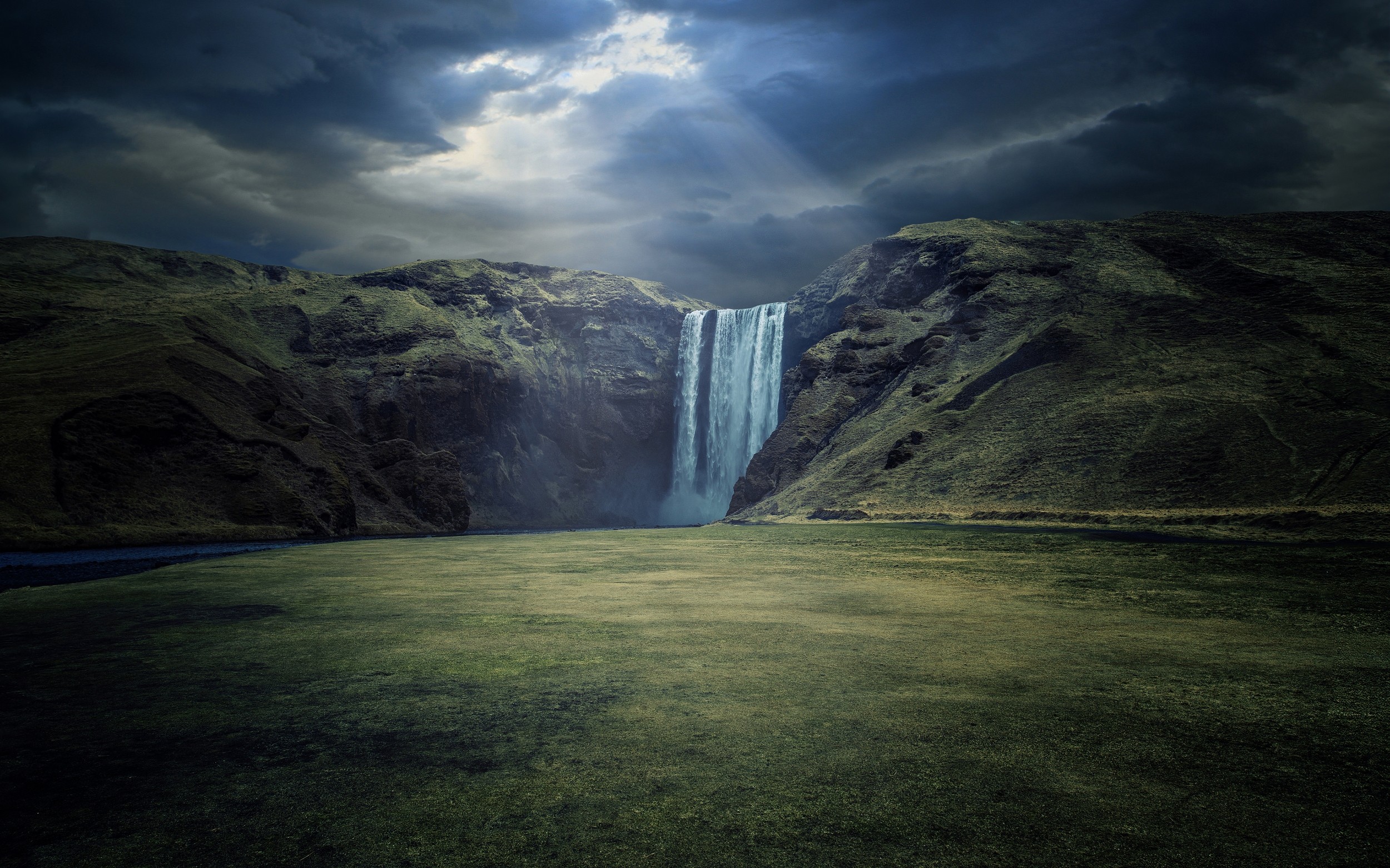 Skogafoss Waterfall in Iceland under dramatic clouds HD Wallpaper