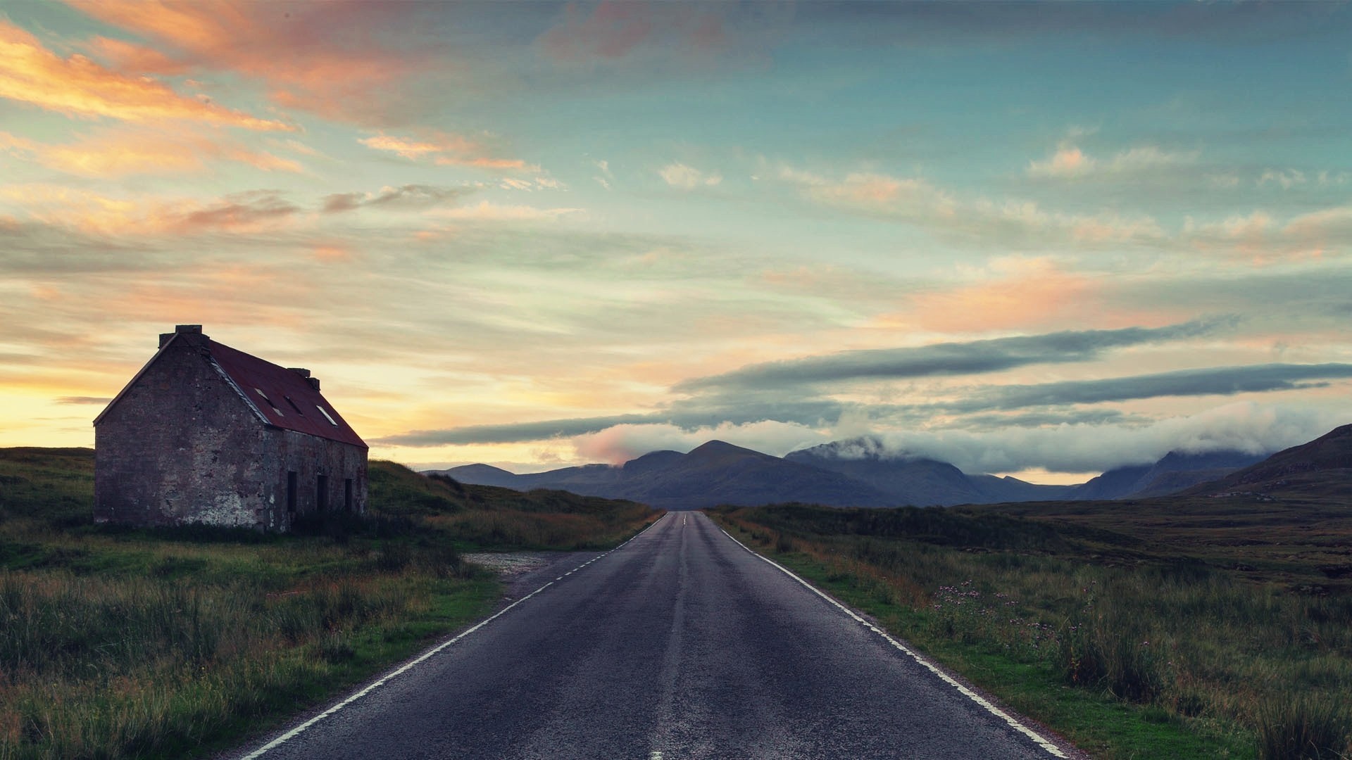 Abandoned house on a road with mountains and sunset sky HD Wallpaper