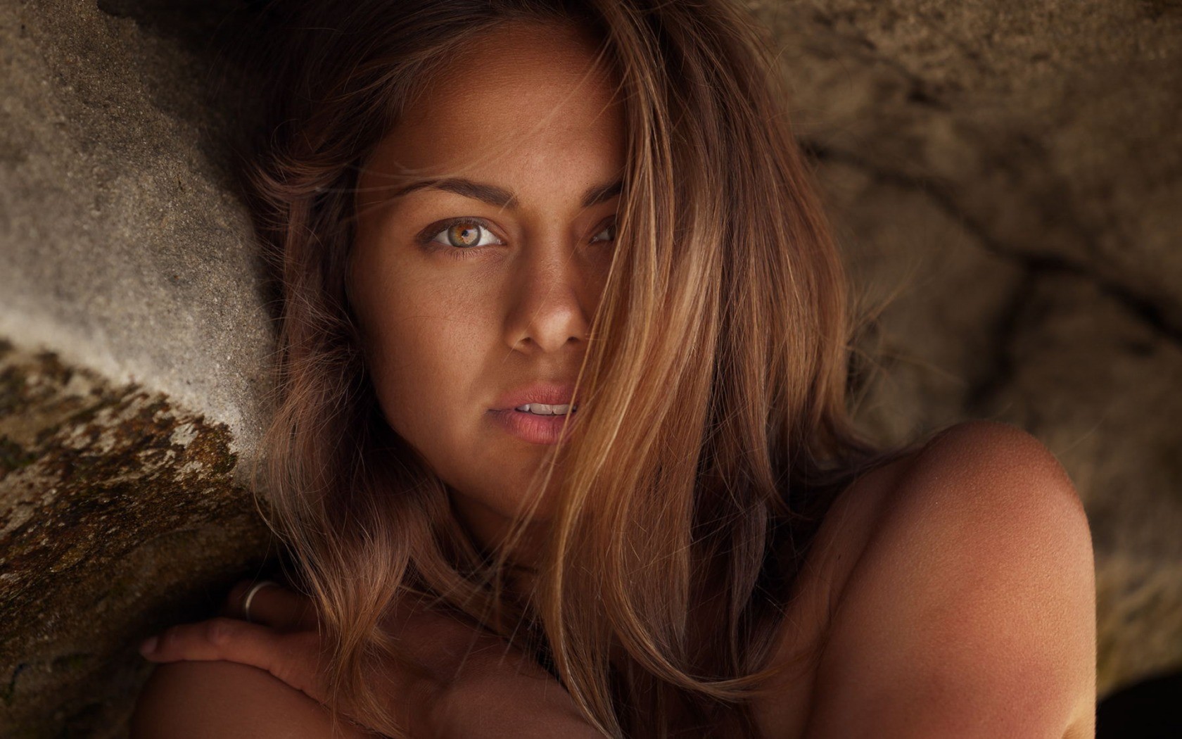 Woman with long brown hair posing near rocks HD Wallpaper