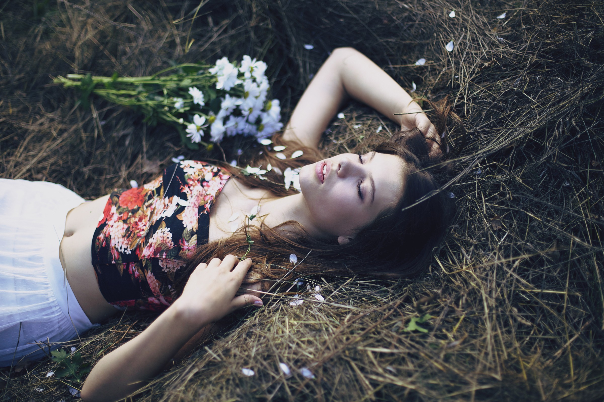 Woman lying in dry grass with flowers HD Wallpaper