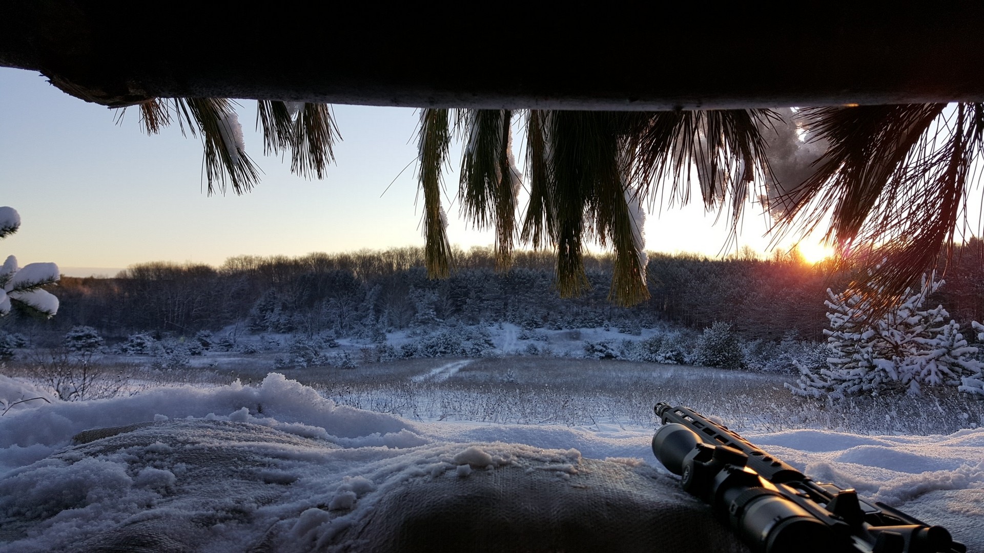 Sniper rifle in a snowy winter landscape at sunrise HD Wallpaper