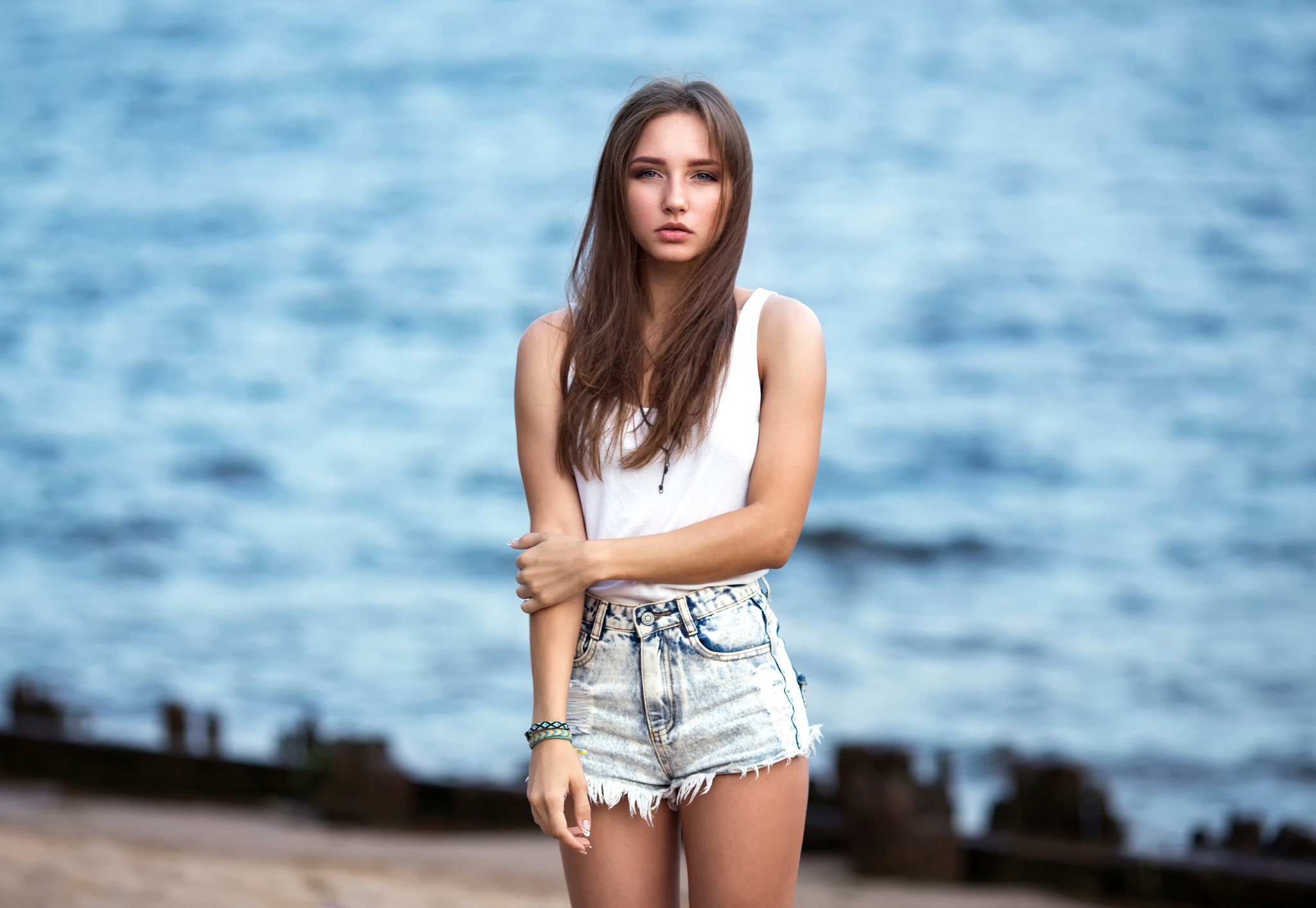 Woman in denim shorts and white tank top by the water HD Wallpaper
