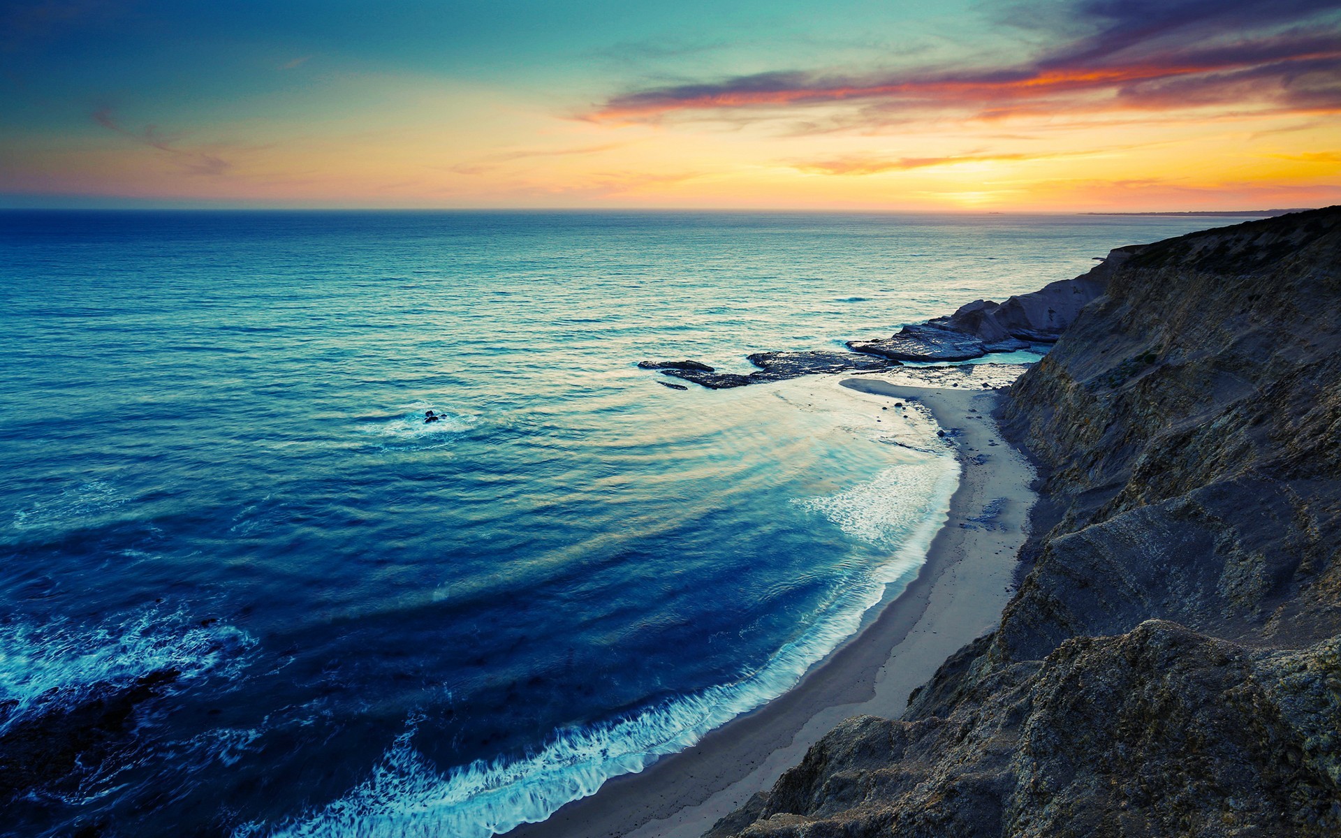 Ocean waves crash on a sandy beach at sunset HD Wallpaper