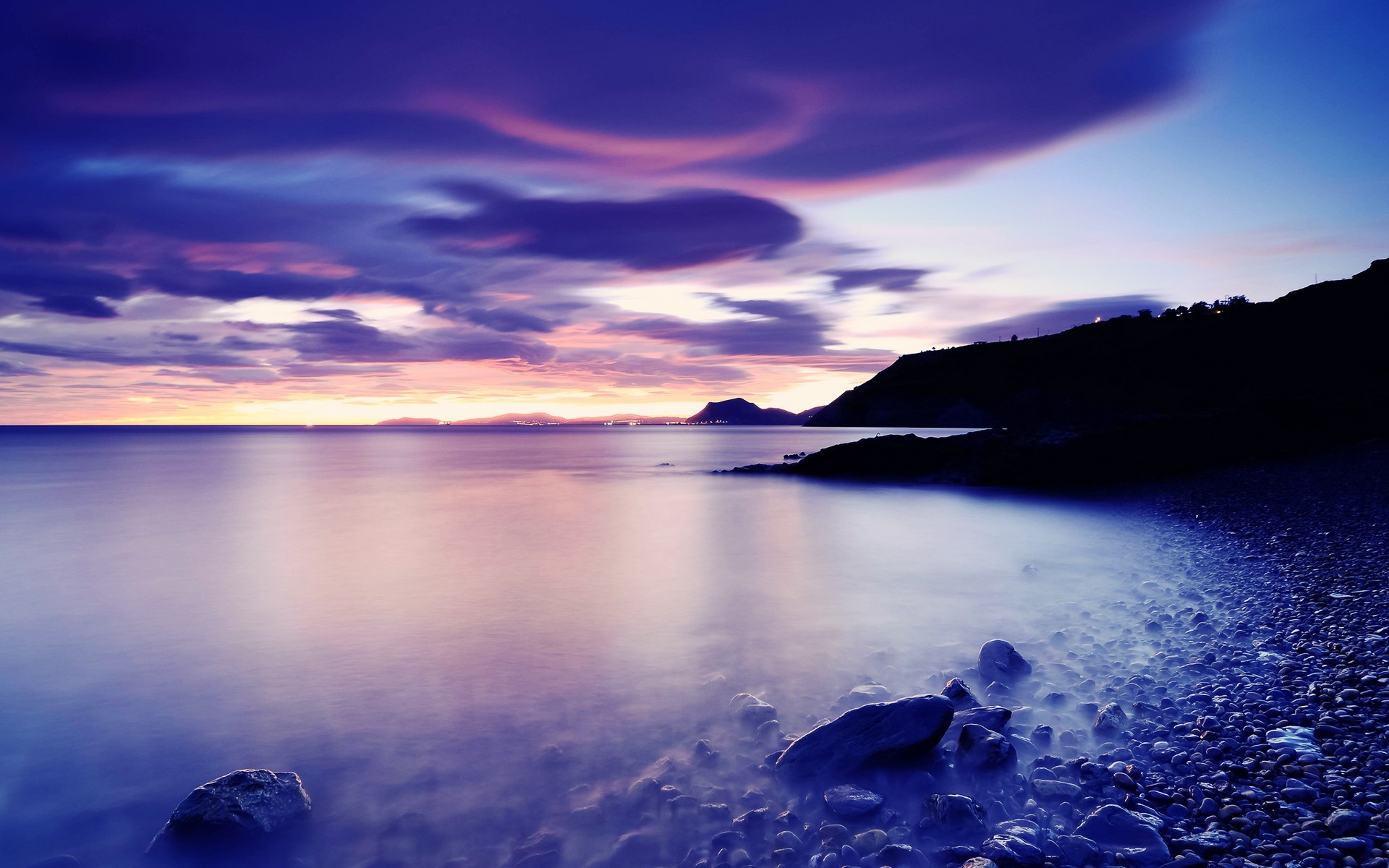 Purple sunset over a rocky coast and calm sea HD Wallpaper