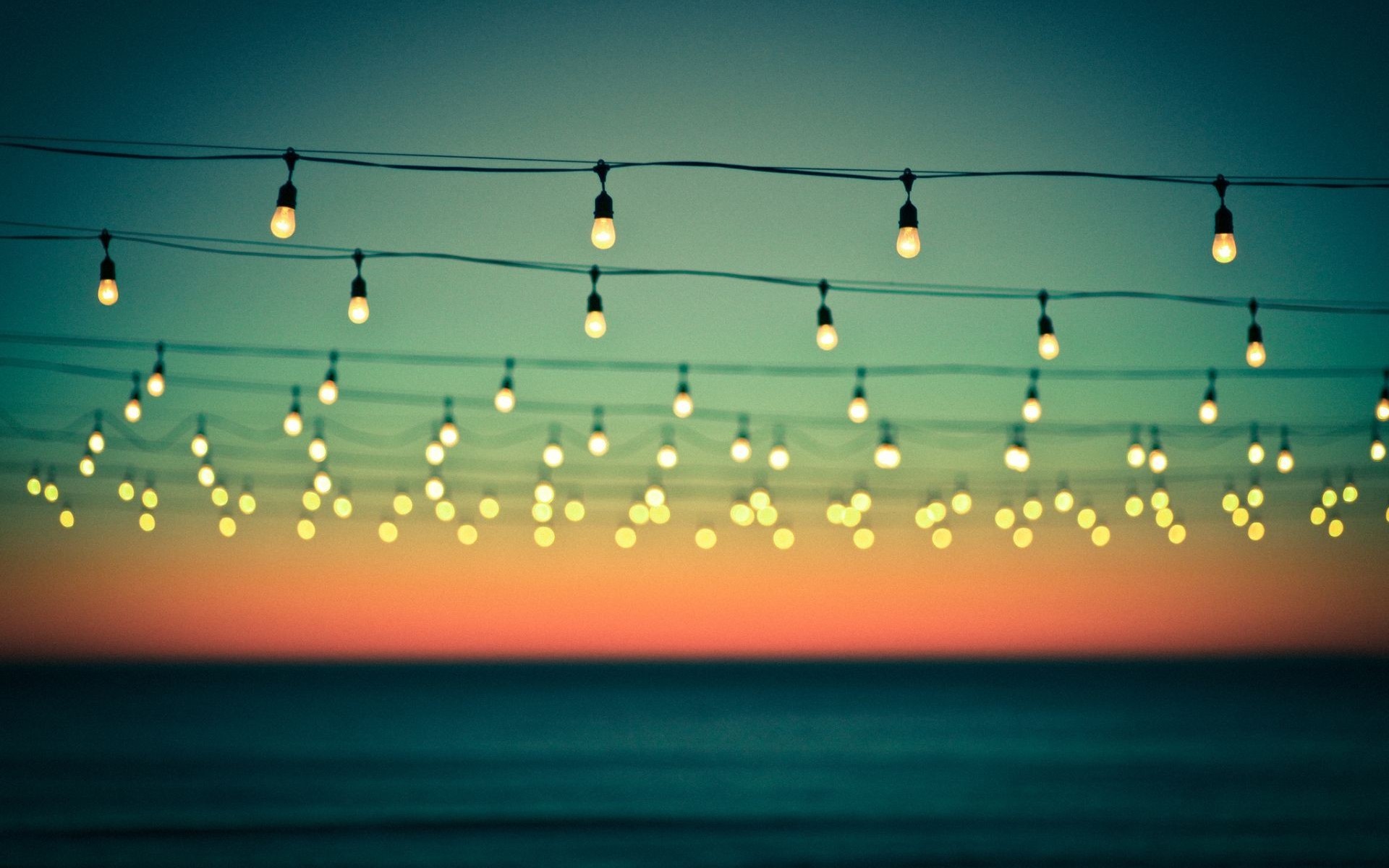 String lights over the sea at dusk HD Wallpaper
