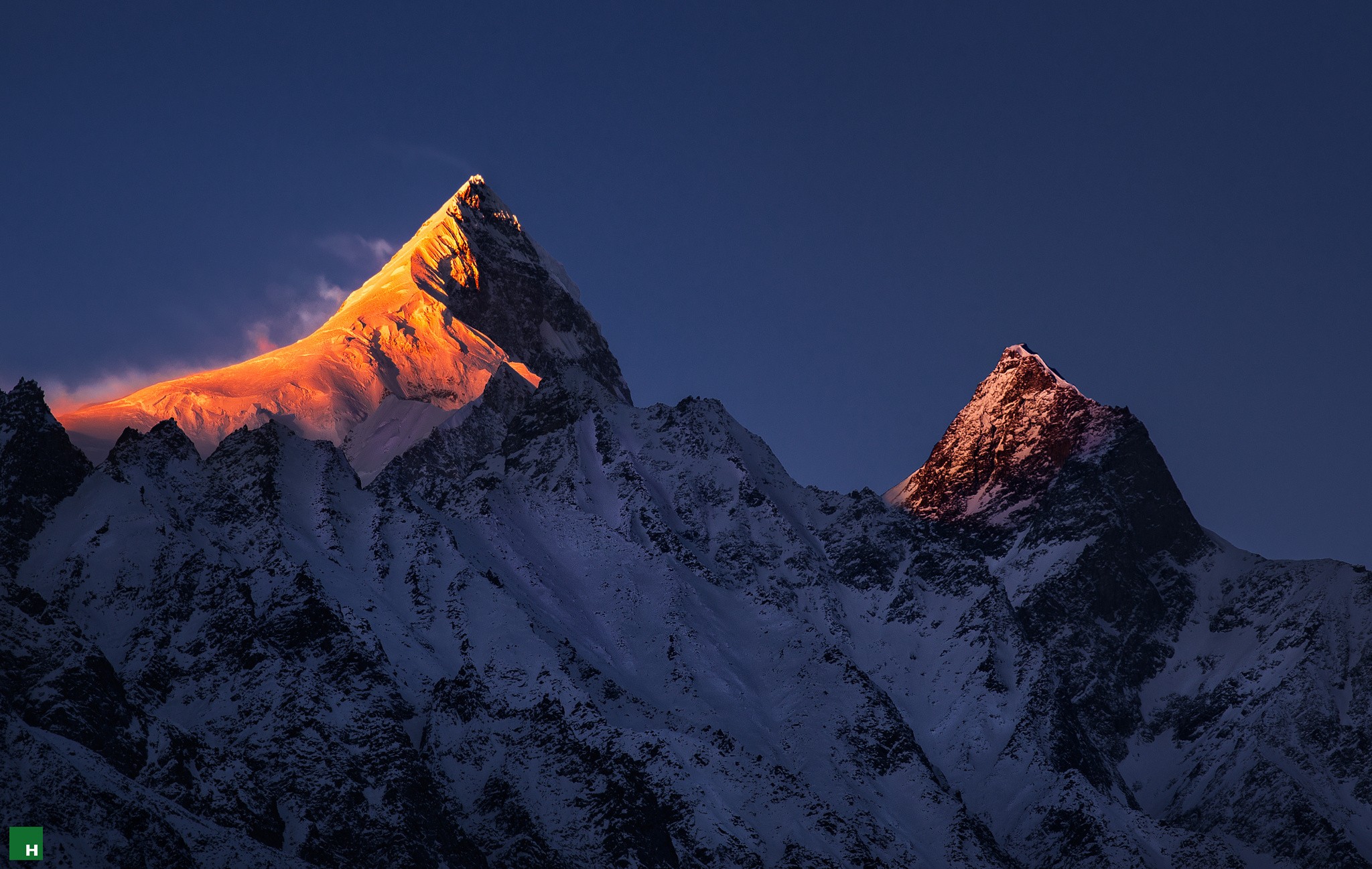 Snow-capped mountains illuminated by golden sunrise HD Wallpaper