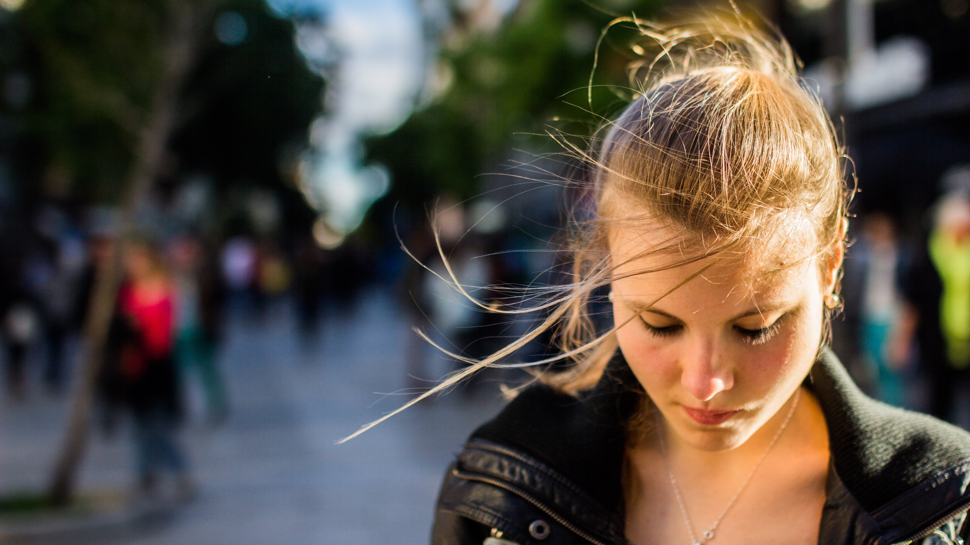 A young woman with blonde hair looking down HD Wallpaper