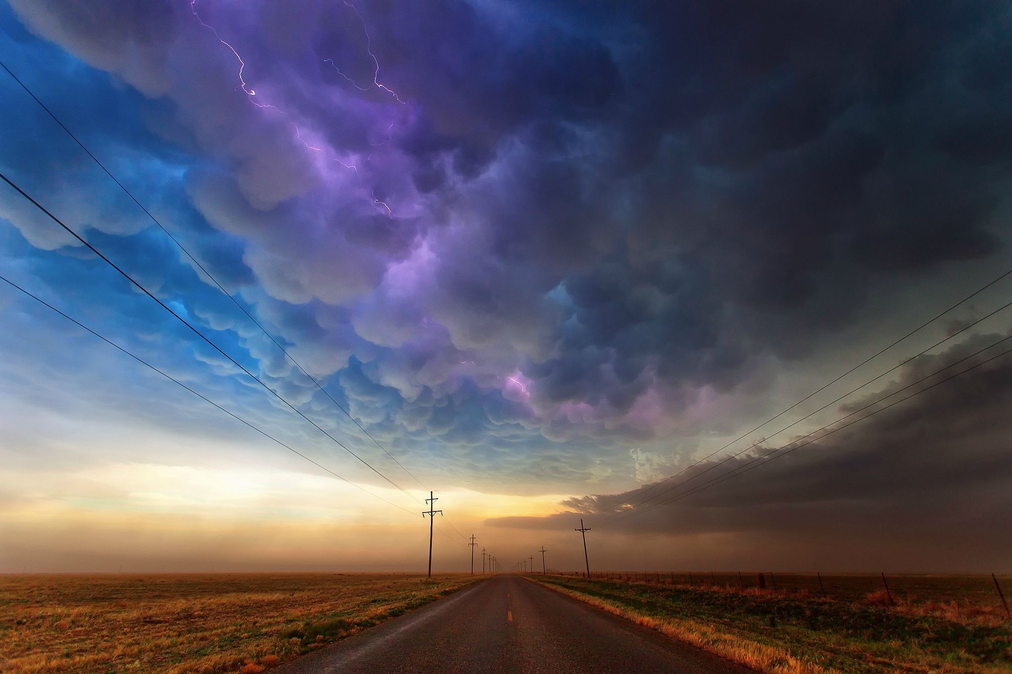 Stormy sky with lightning over a road HD Wallpaper