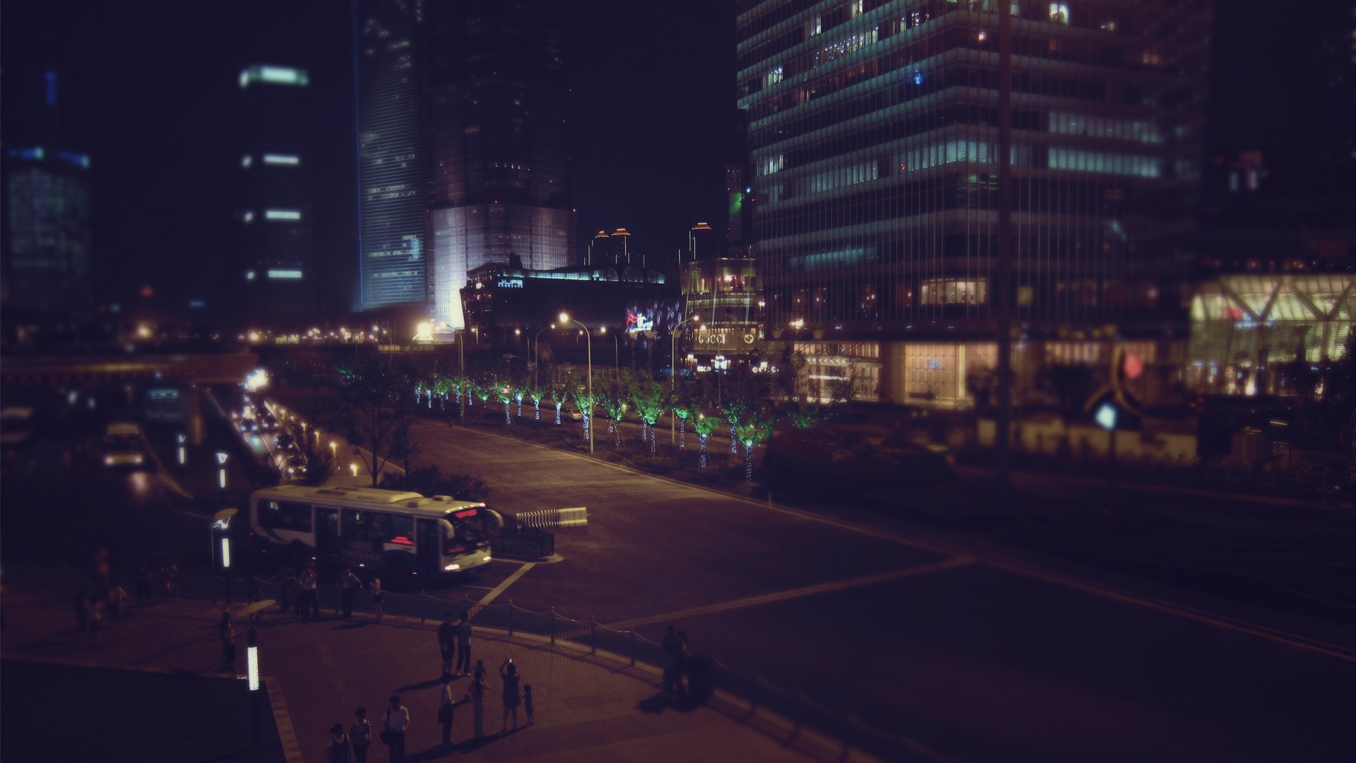 City street at night with buildings and traffic HD Wallpaper