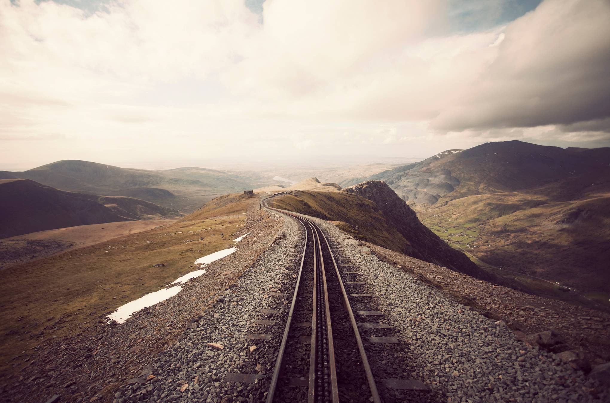 Railway tracks winding through a mountainous landscape HD Wallpaper
