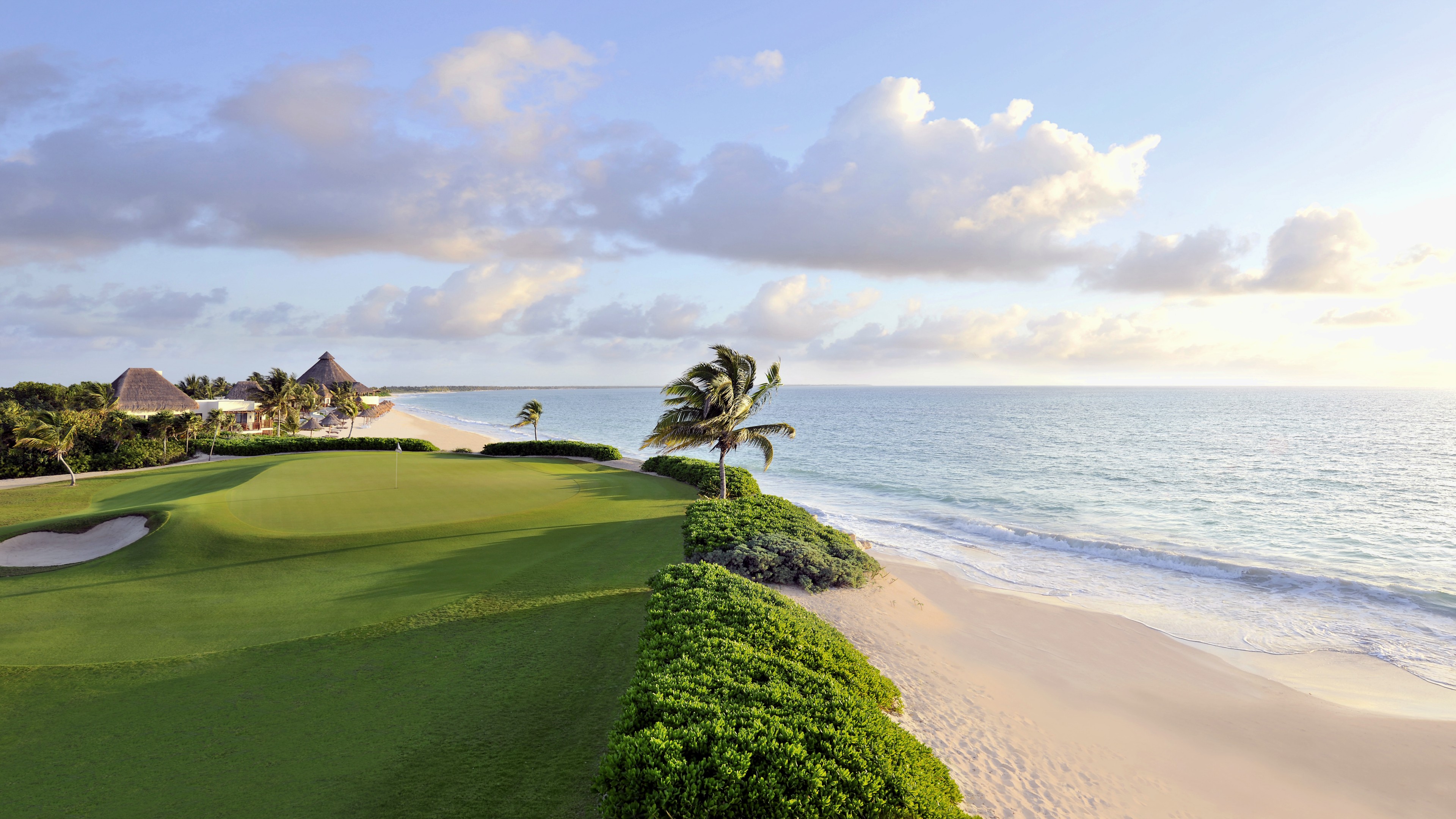 Golf course by the sea with palm trees and clouds HD Wallpaper