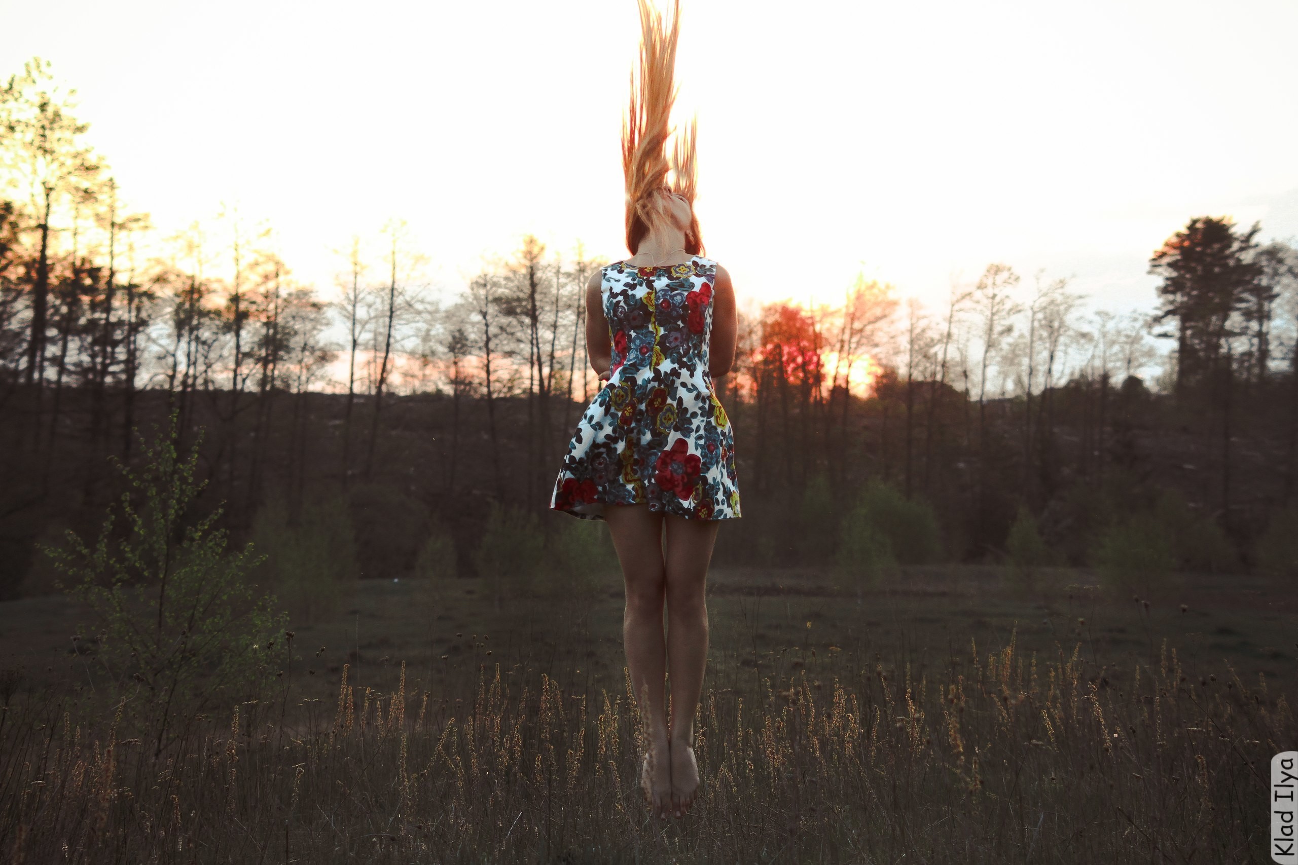 Woman with long hair in a floral dress in a field HD Wallpaper