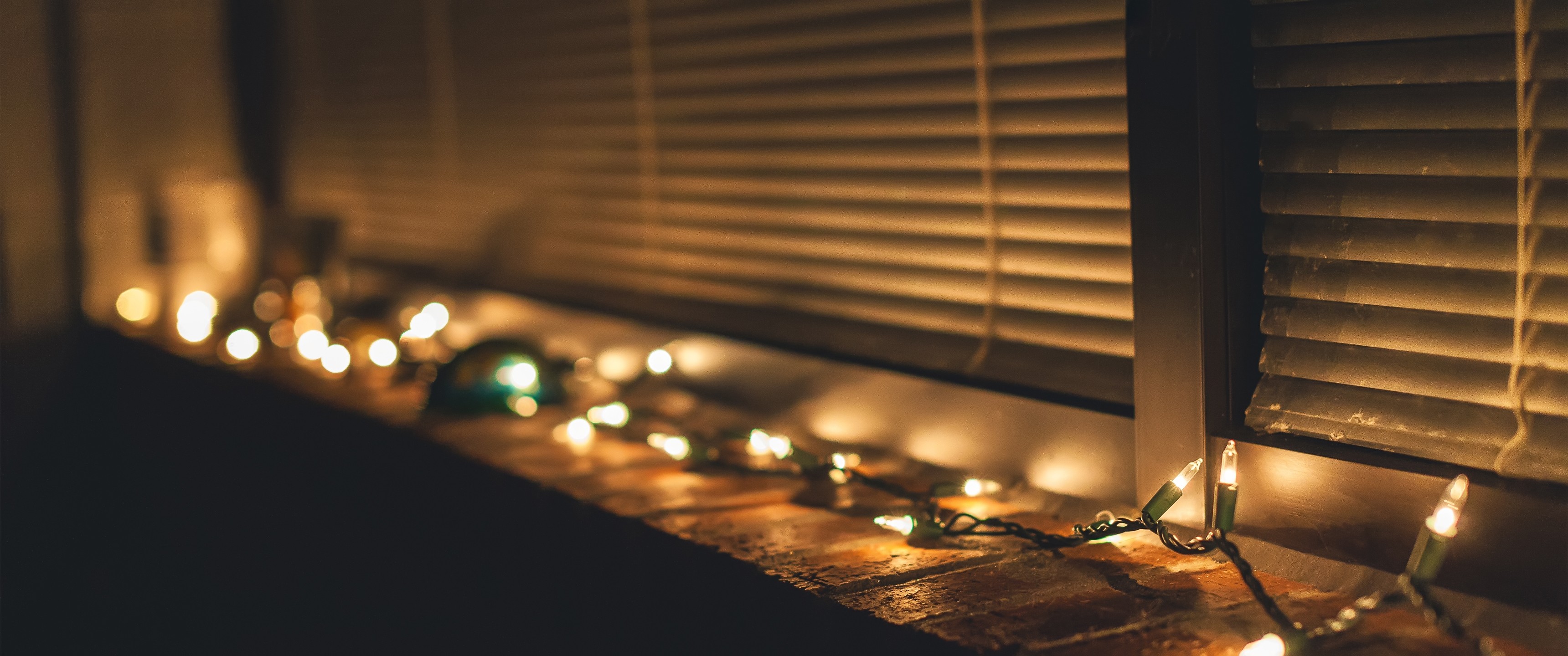 Christmas lights on a windowsill with blinds HD Wallpaper