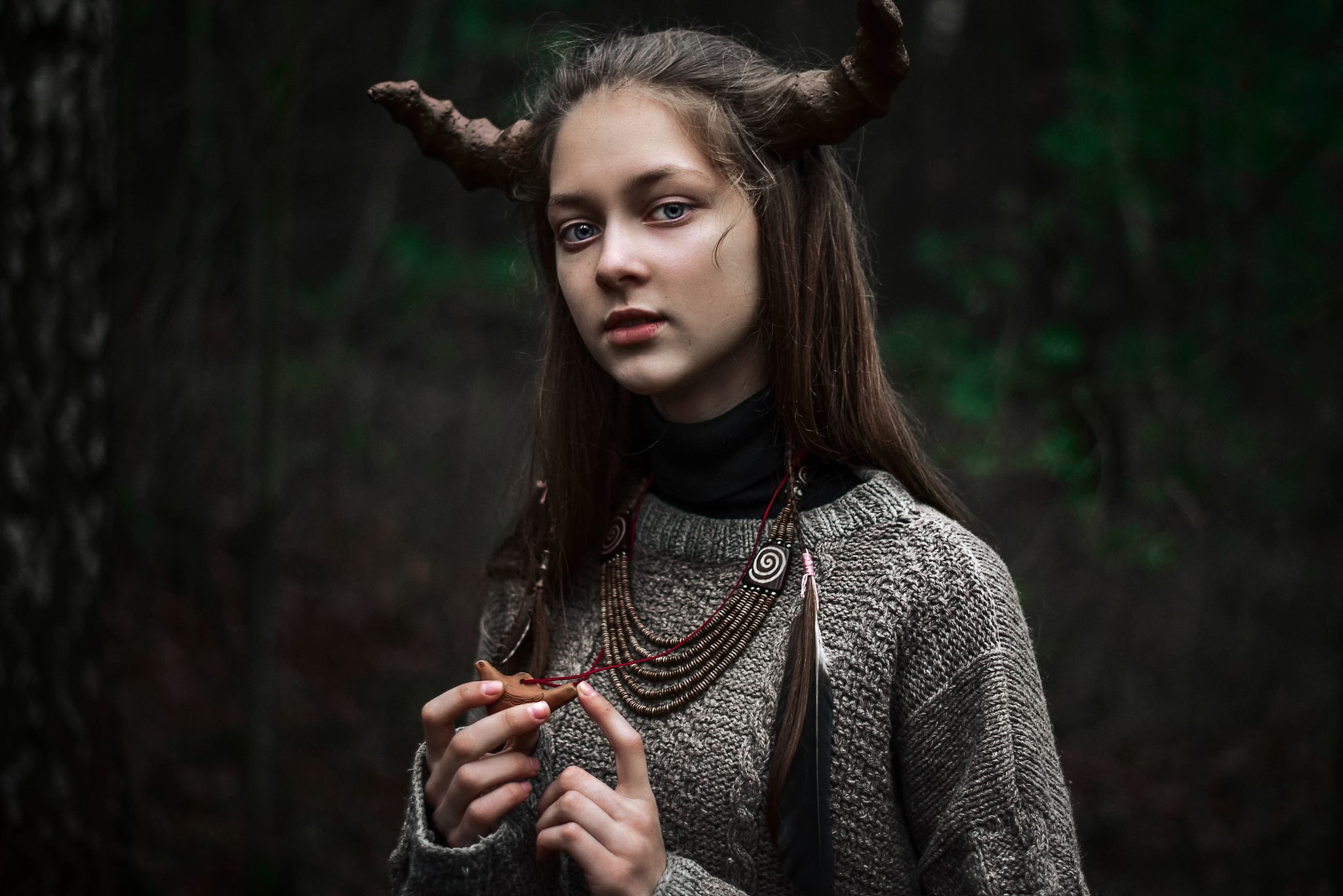 Young woman with horns and necklace in forest HD Wallpaper