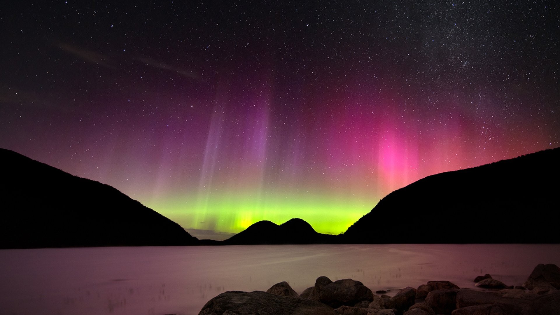Aurora Borealis over a lake with mountains and stars HD Wallpaper