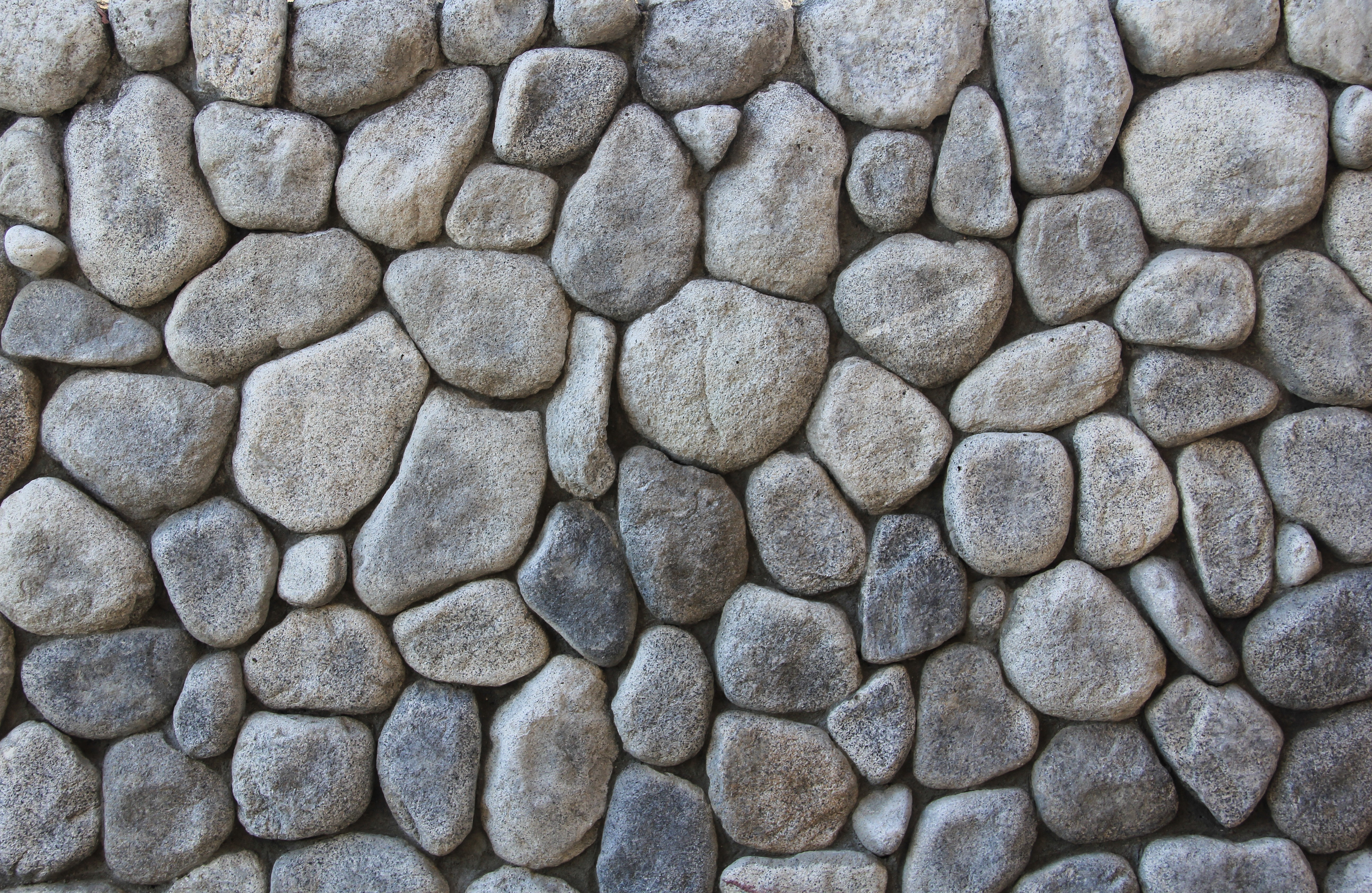 A textured wall made of various sized rocks HD Wallpaper