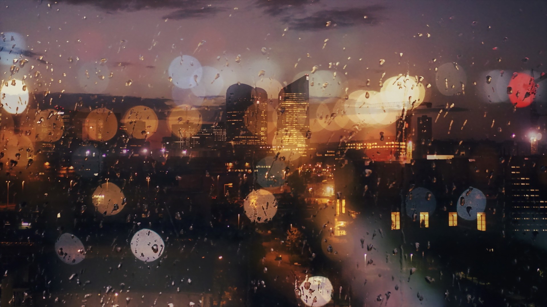 Cityscape at dusk through a rain-streaked window HD Wallpaper