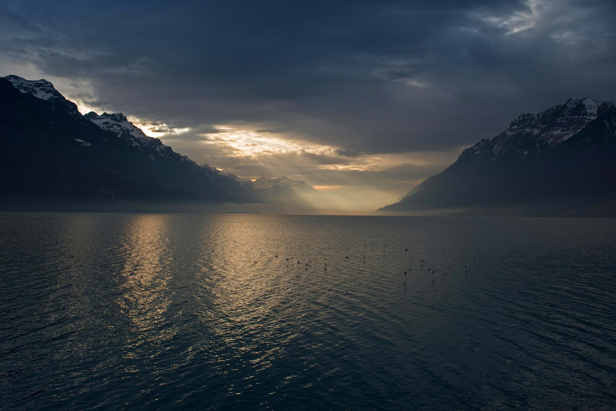 Sun rays over a lake with mountains in Switzerland HD Wallpaper