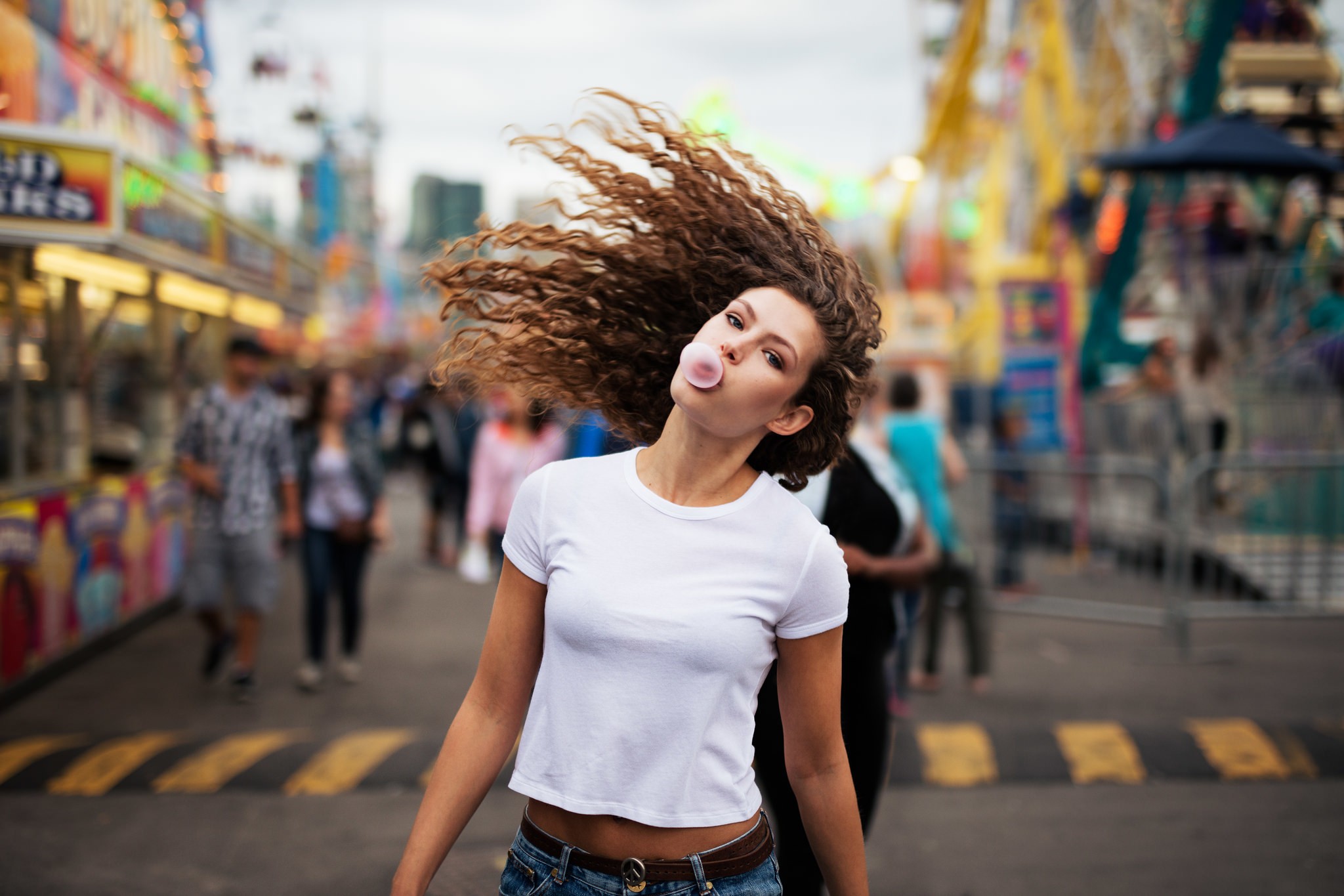 Woman blowing bubble gum at a carnival HD Wallpaper