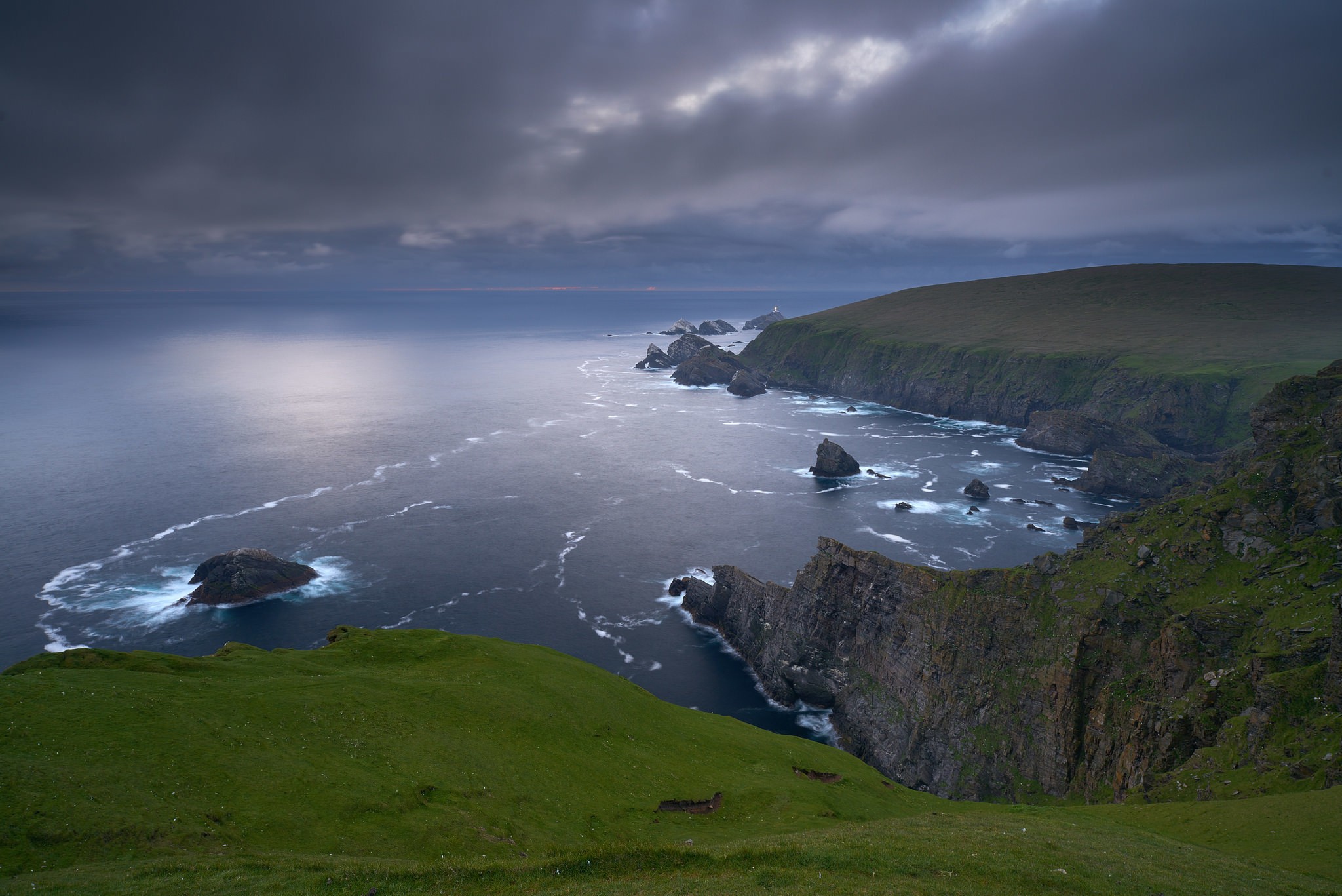 Dramatic coastal cliffs with waves crashing against rocks HD Wallpaper