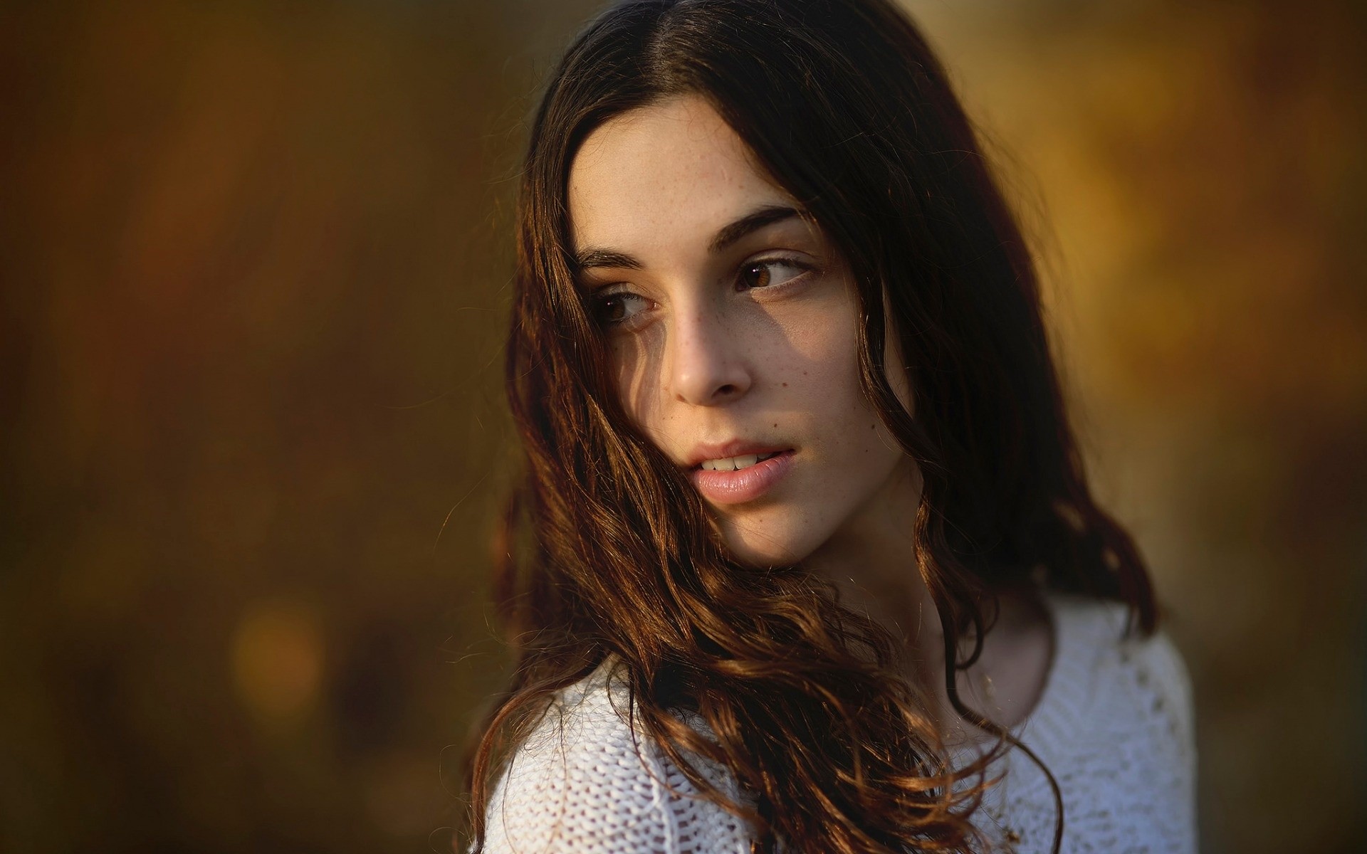 Young woman with long brown hair looking away HD Wallpaper