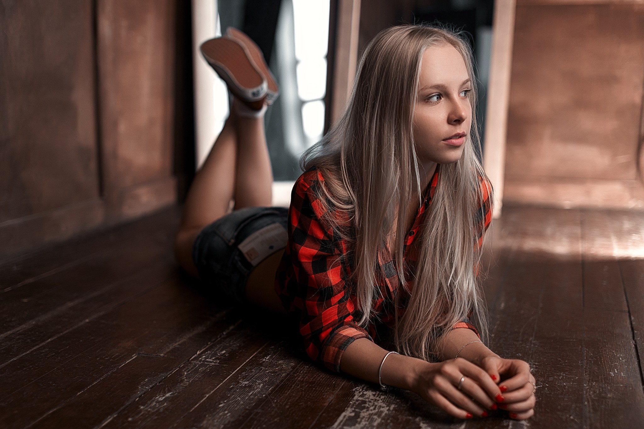 Woman in jean shorts and plaid shirt lying on floor HD Wallpaper