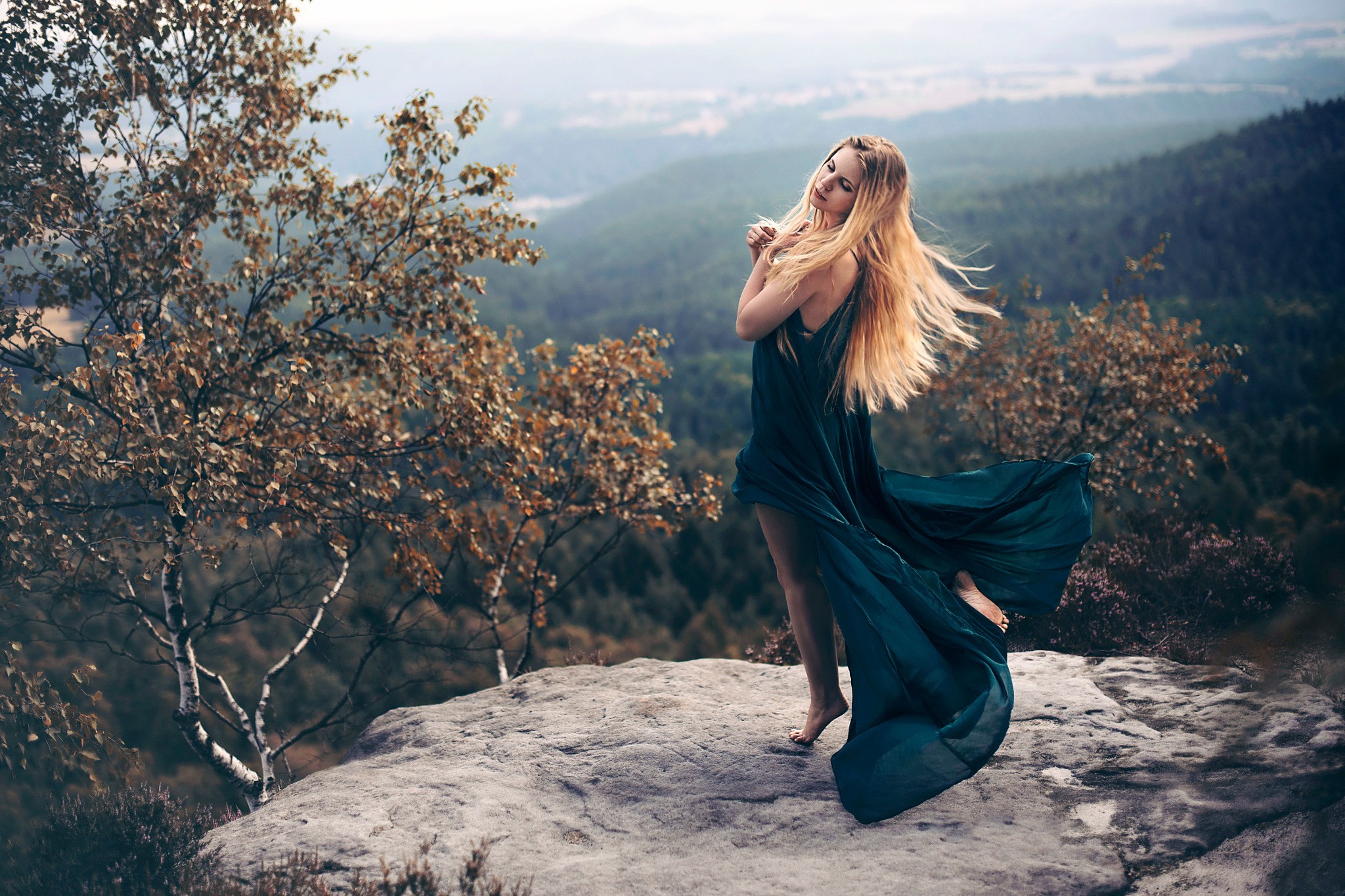 Woman in a flowing dress on a rocky outcrop HD Wallpaper