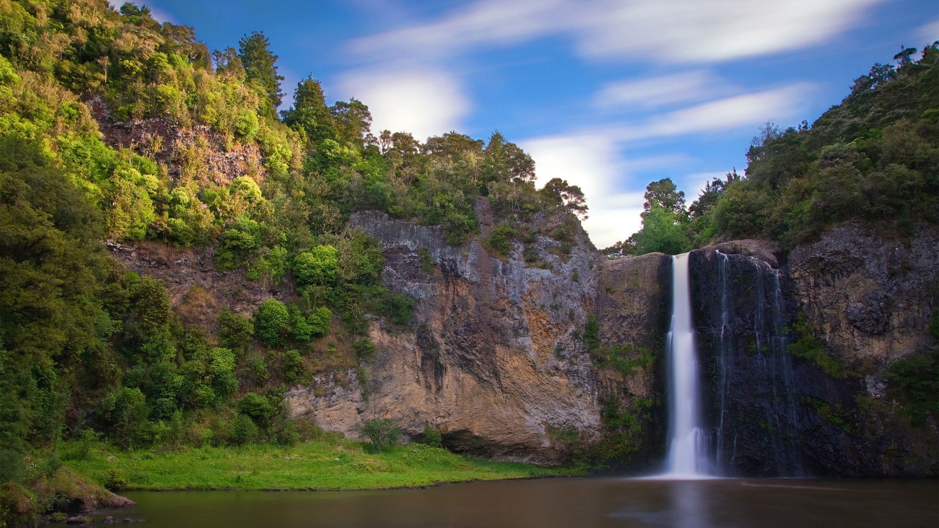 Waterfall cascading down a rocky cliff surrounded by trees HD Wallpaper