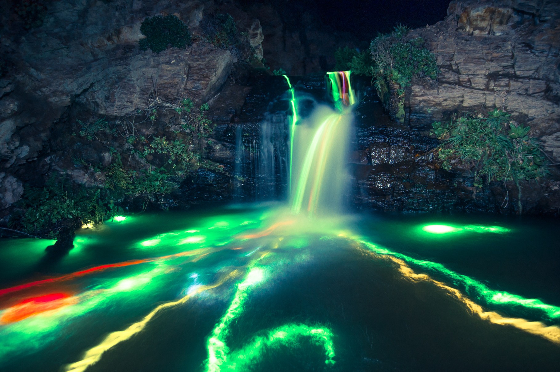 Colorful waterfall at night with glowing water HD Wallpaper
