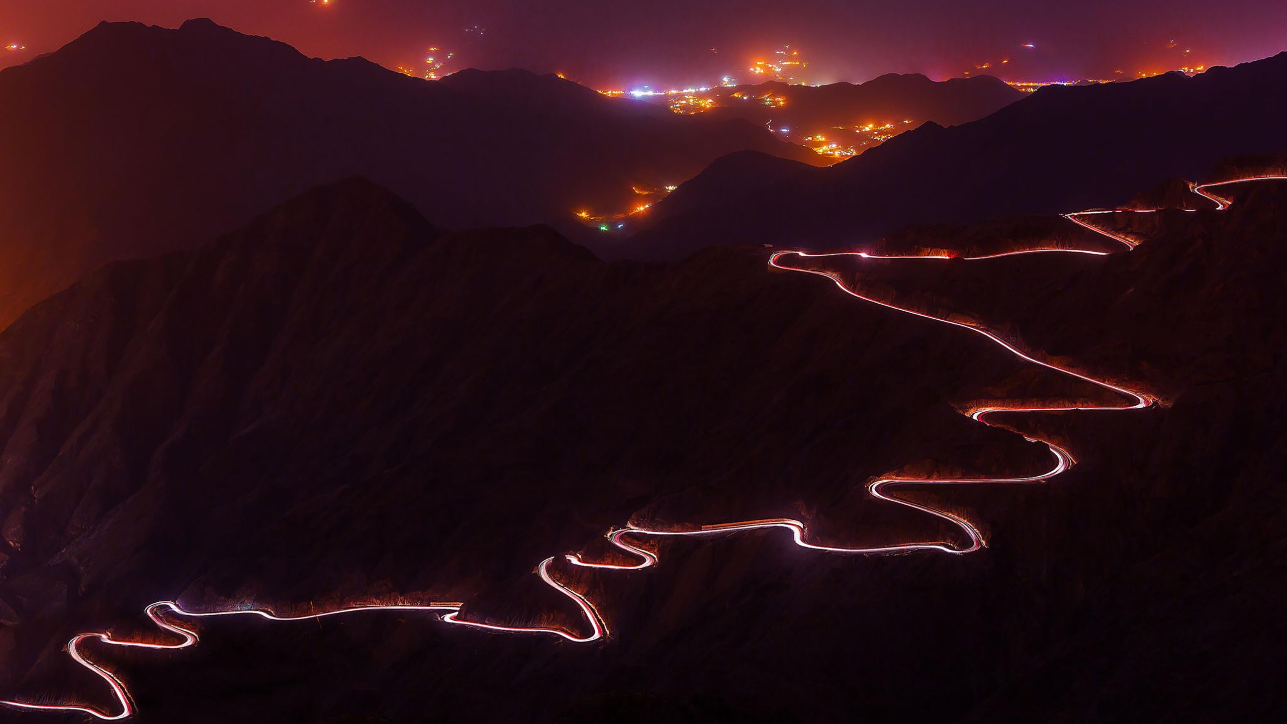 Long exposure of a winding mountain road at night HD Wallpaper