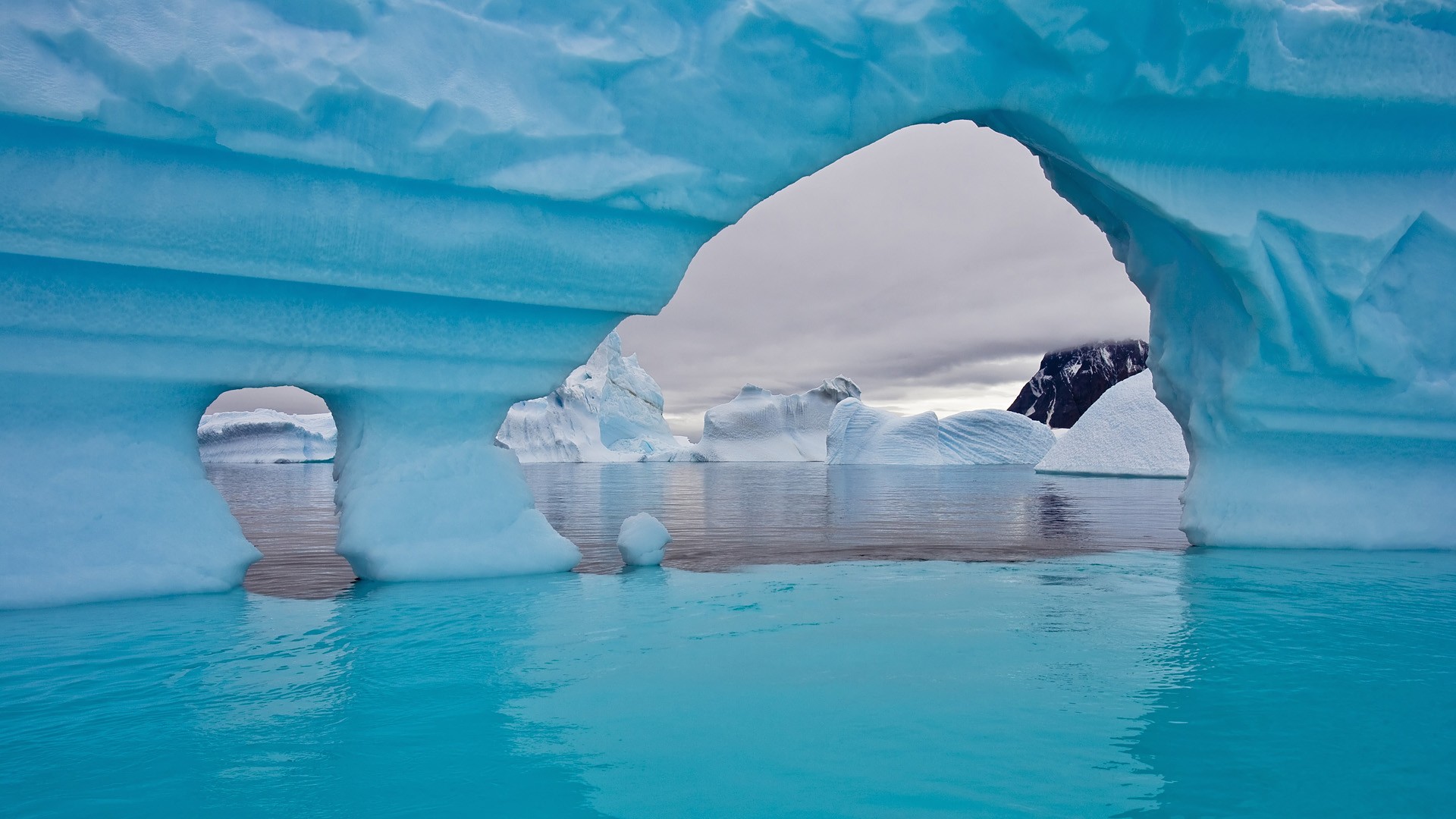 Icebergs and archway in Arctic sea HD Wallpaper