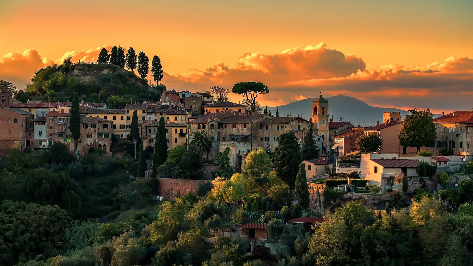 Tuscan village at sunset with rolling hills and clouds HD Wallpaper