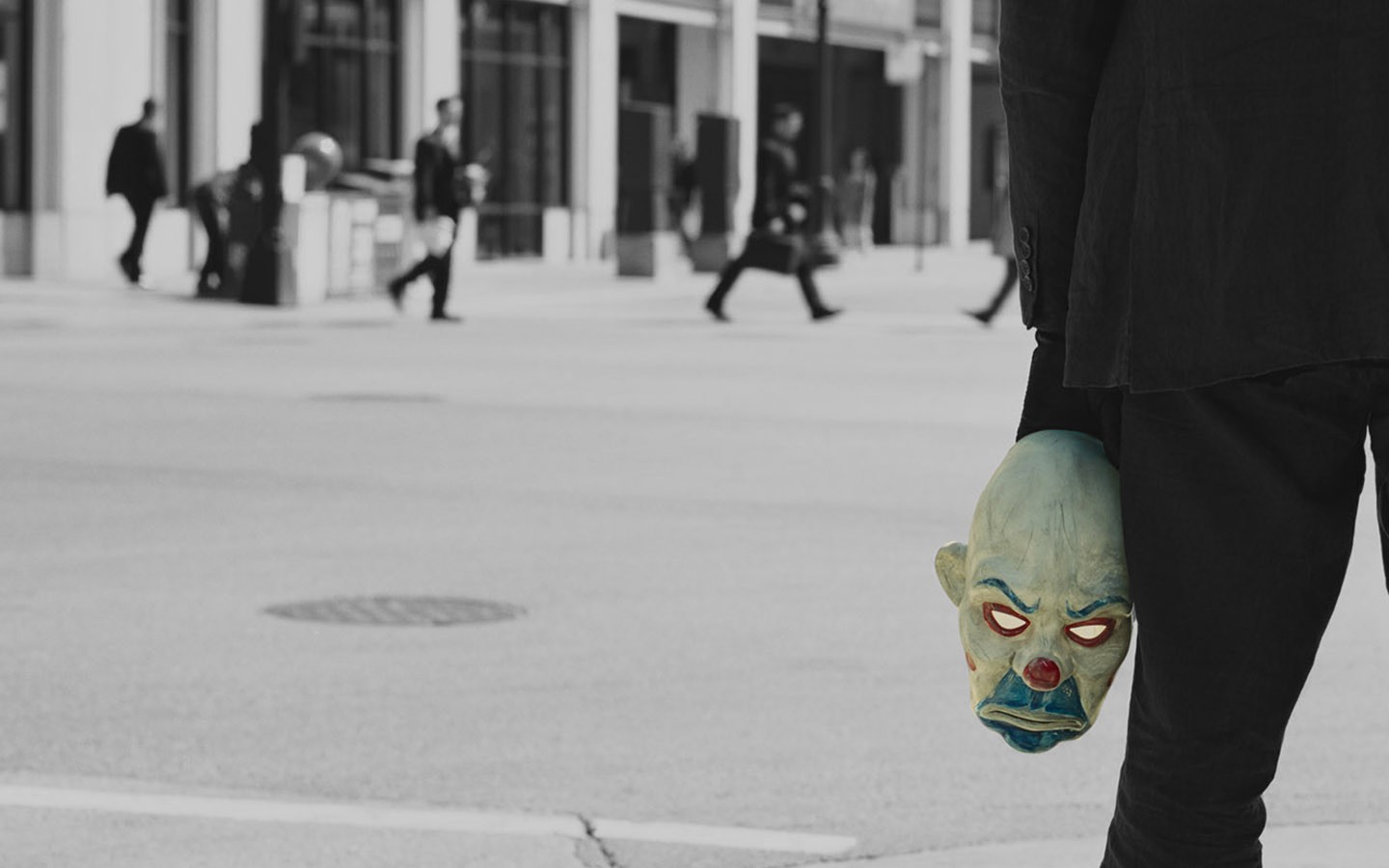 The Joker mask held by a man in a suit HD Wallpaper