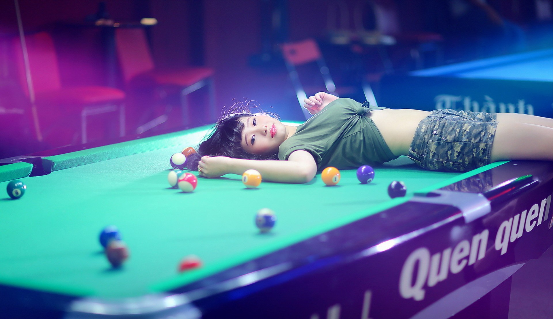 Asian woman lying on a pool table with billiard balls HD Wallpaper