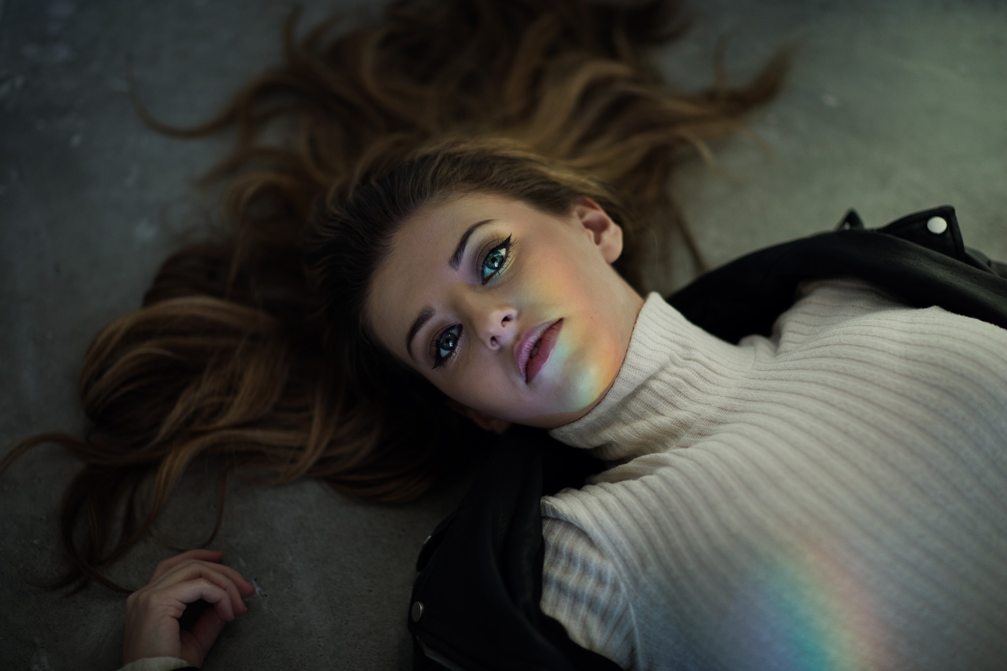 Woman lying on the floor with rainbow light on her face HD Wallpaper