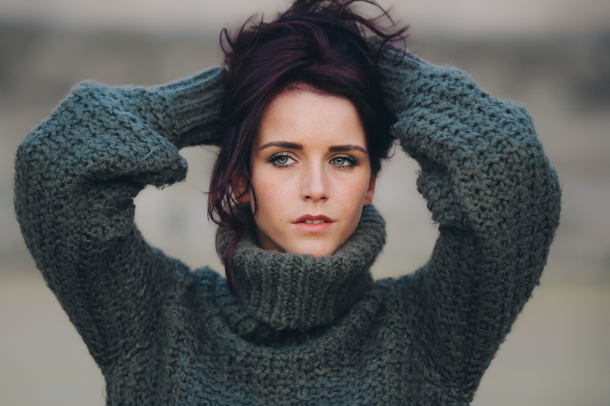 Woman with hands in hair wearing a turtleneck sweater HD Wallpaper