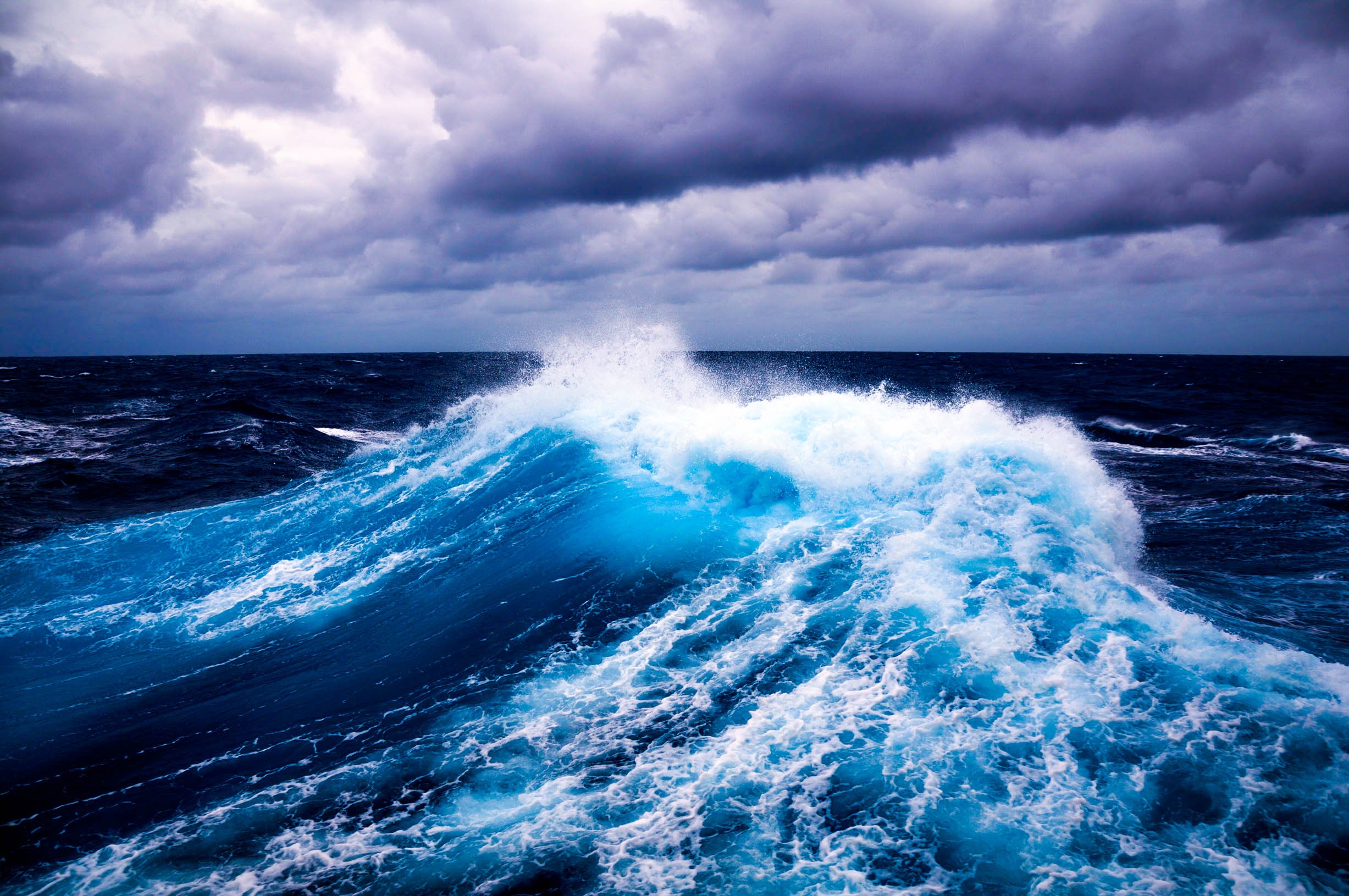 Crashing ocean wave under a stormy sky HD Wallpaper