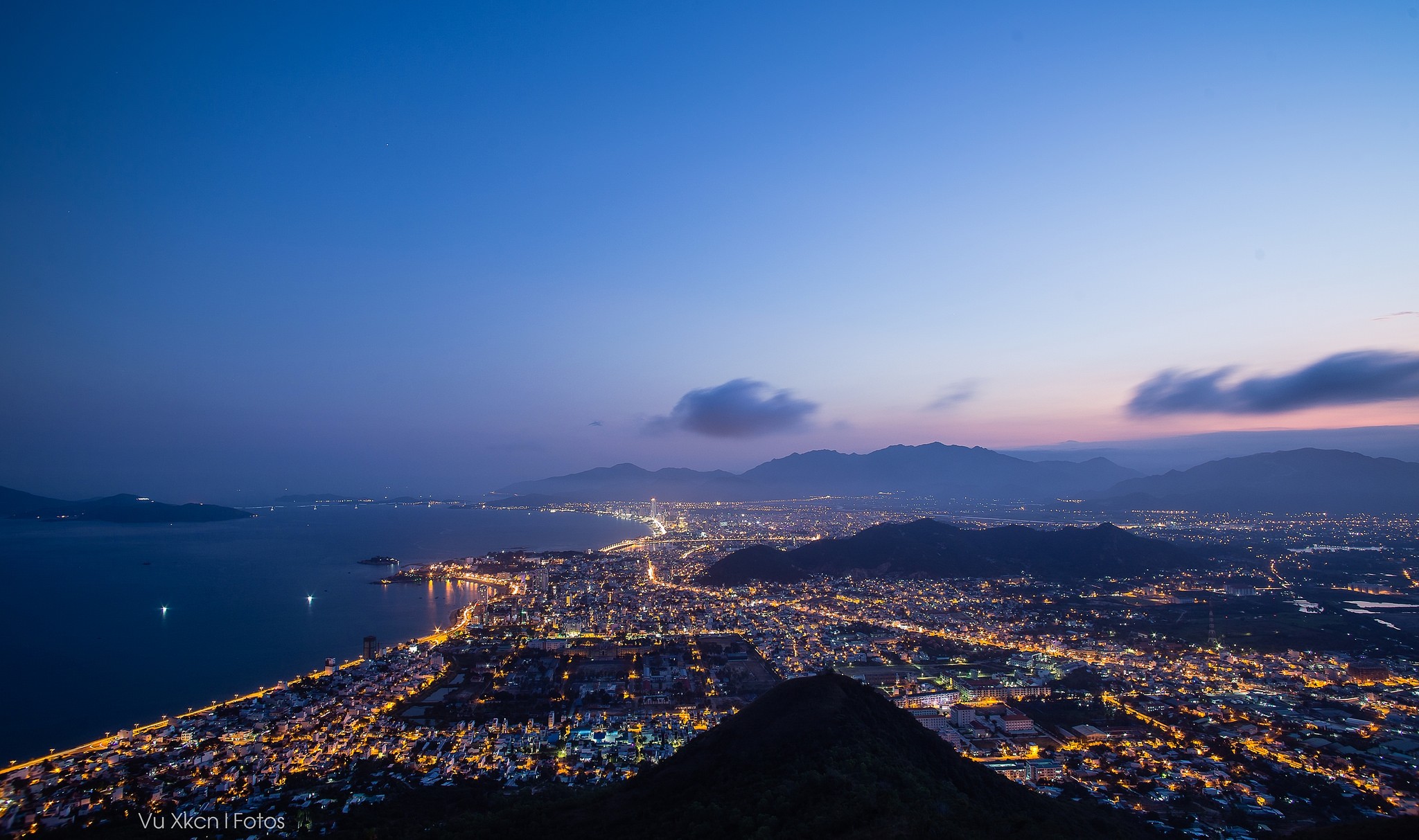City lights at dusk over a bay and mountains HD Wallpaper