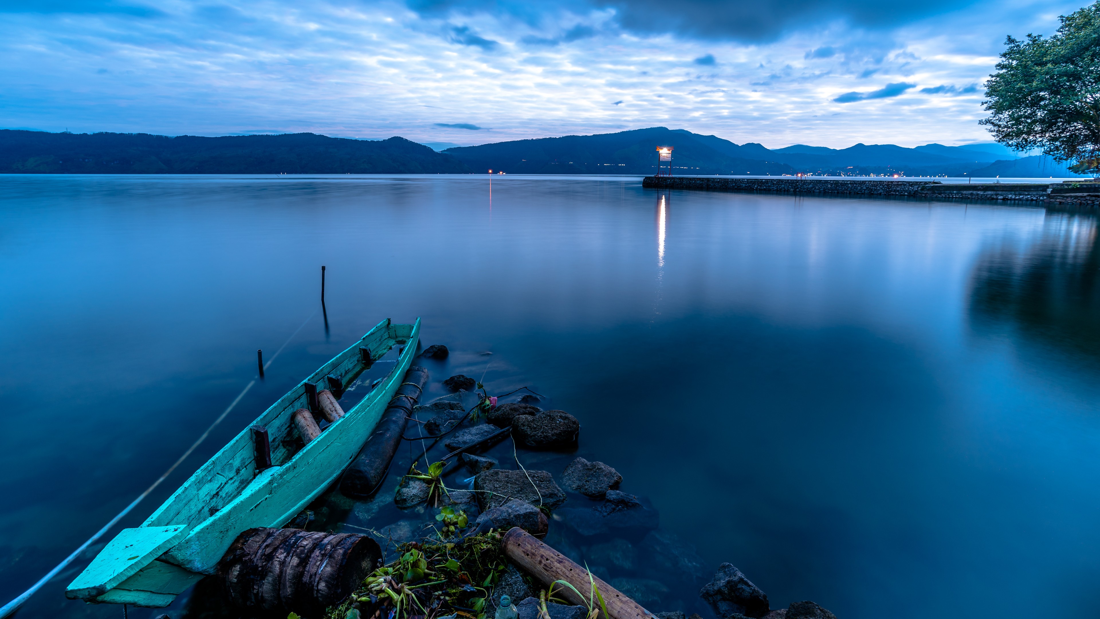 Turquoise boat on a calm lake at dusk in Indonesia HD Wallpaper