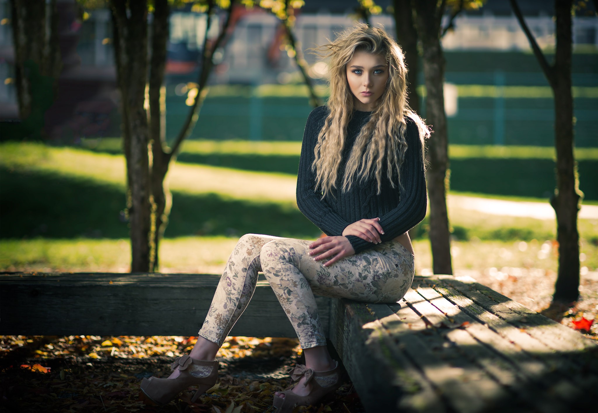 Blonde woman sitting on a wooden bench outdoors HD Wallpaper
