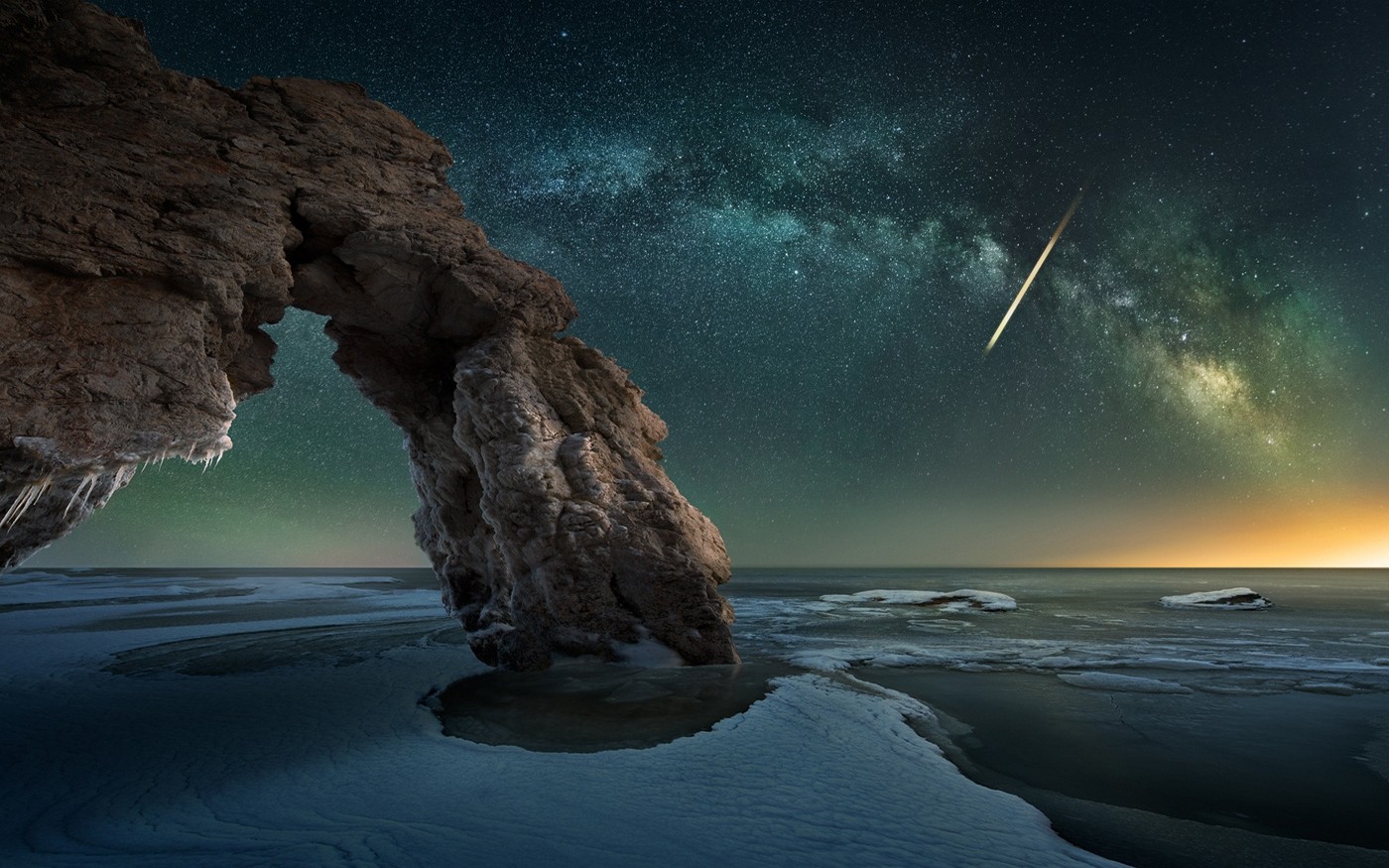 Milky Way over icy rock arch and frozen sea HD Wallpaper