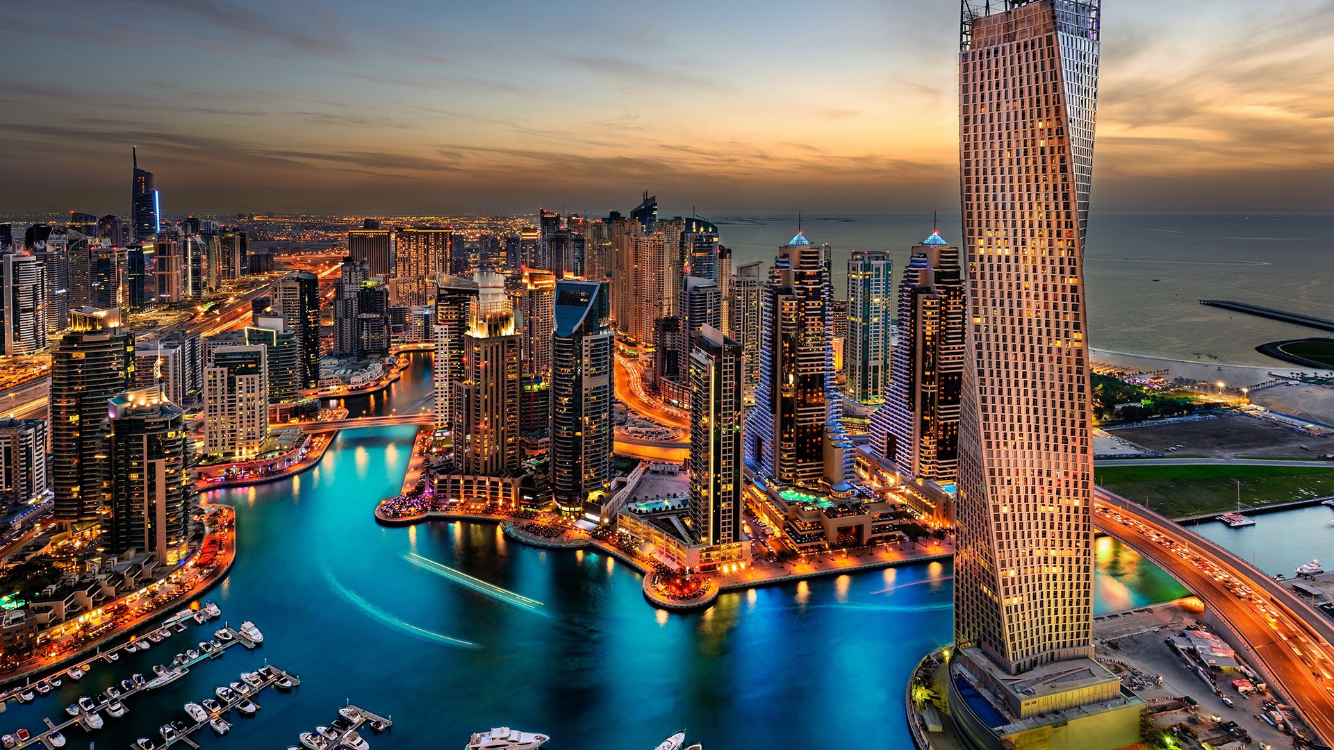 Dubai Marina skyline at dusk with illuminated skyscrapers and water canal HD Wallpaper