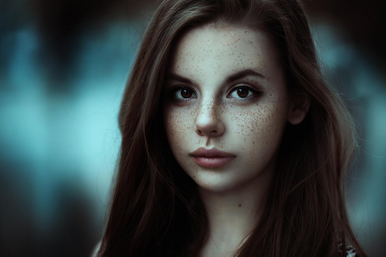 Young woman with freckles looking at the camera HD Wallpaper